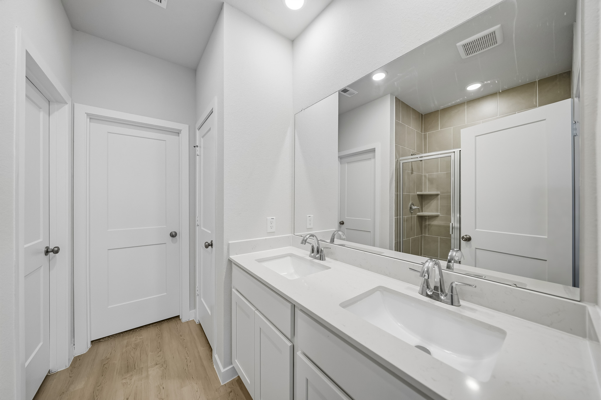 A bathroom with white cabinets.