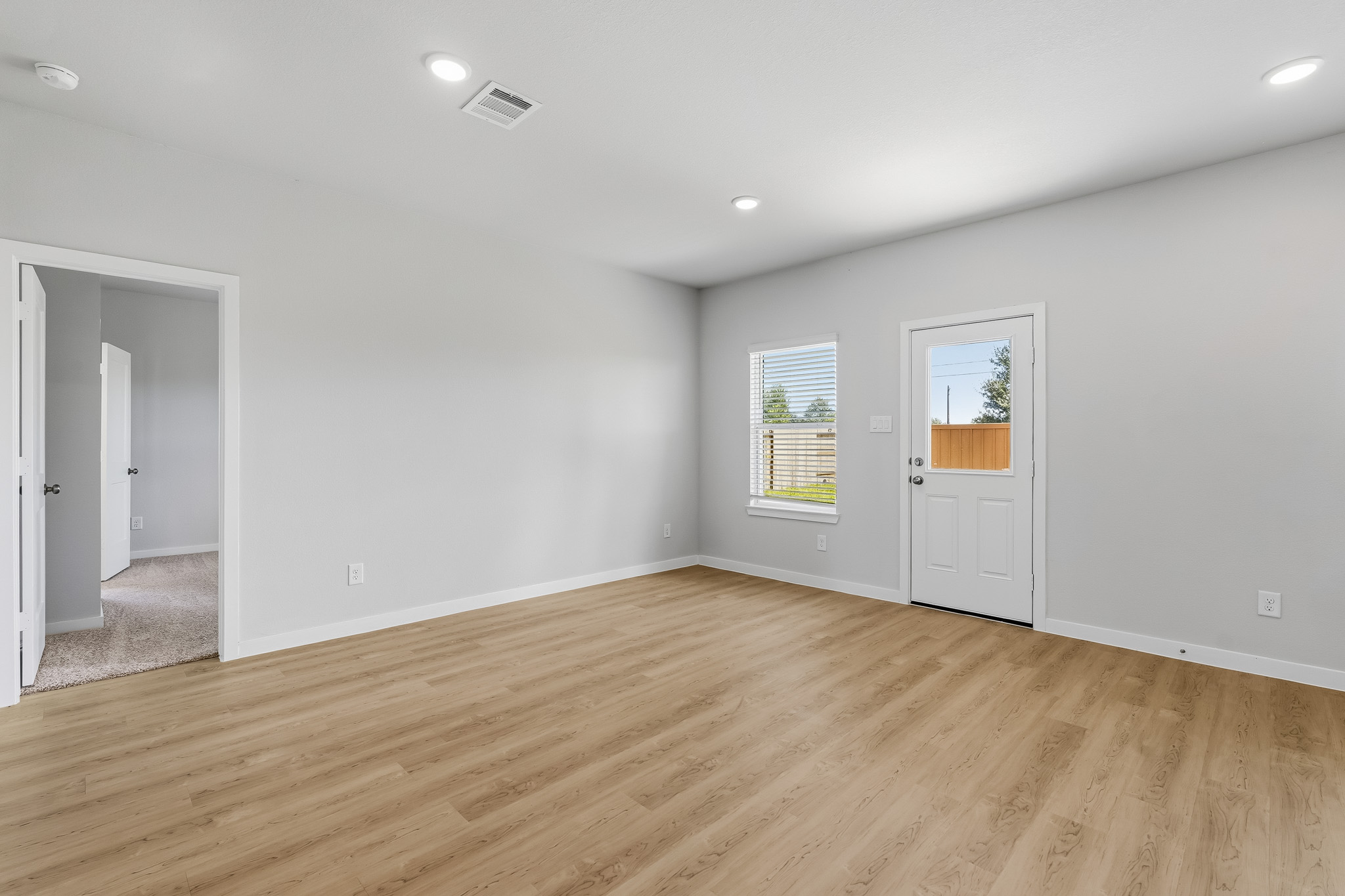 A room with a wood floor and white walls.
