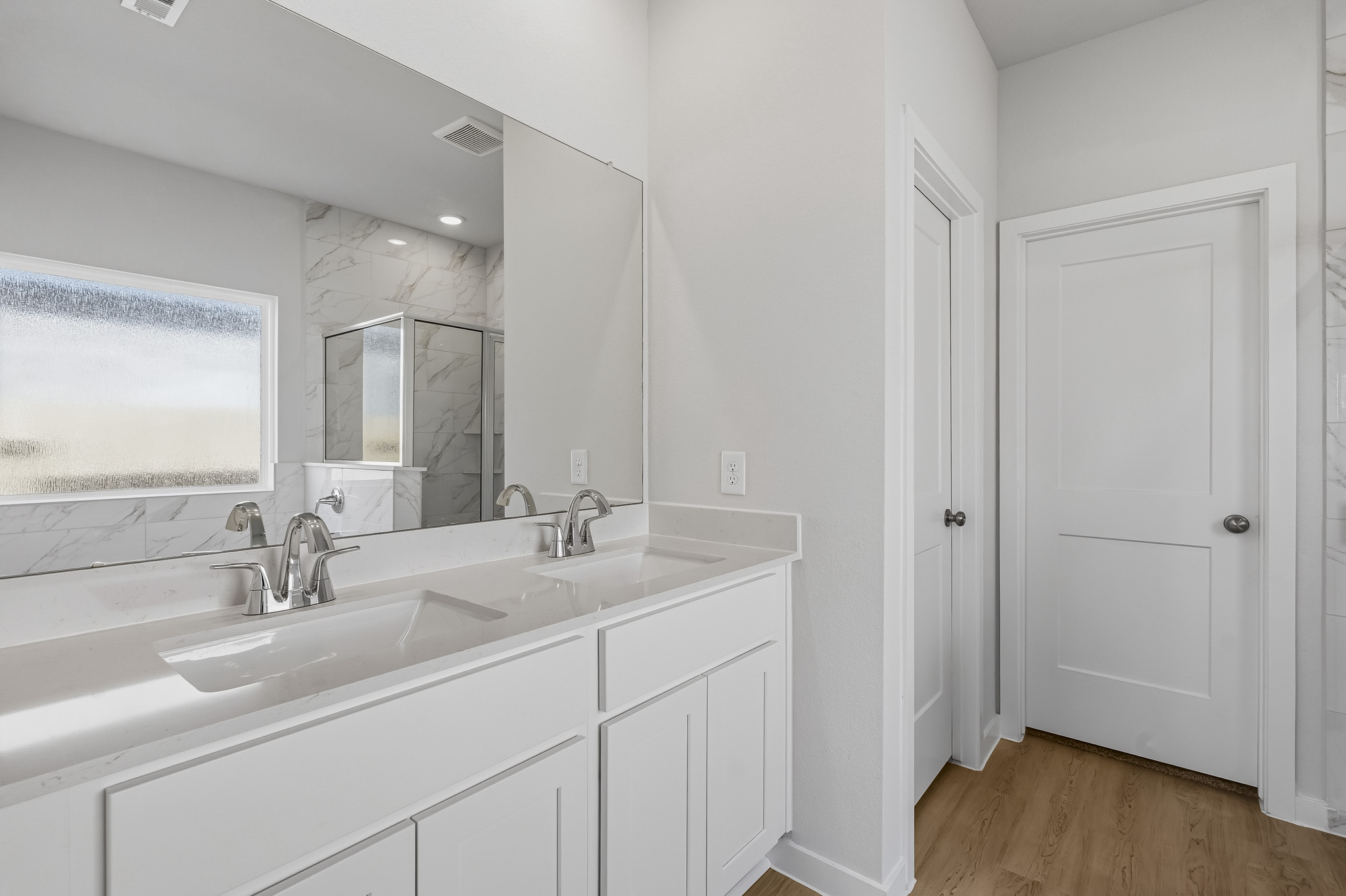 A bathroom with white cabinets.