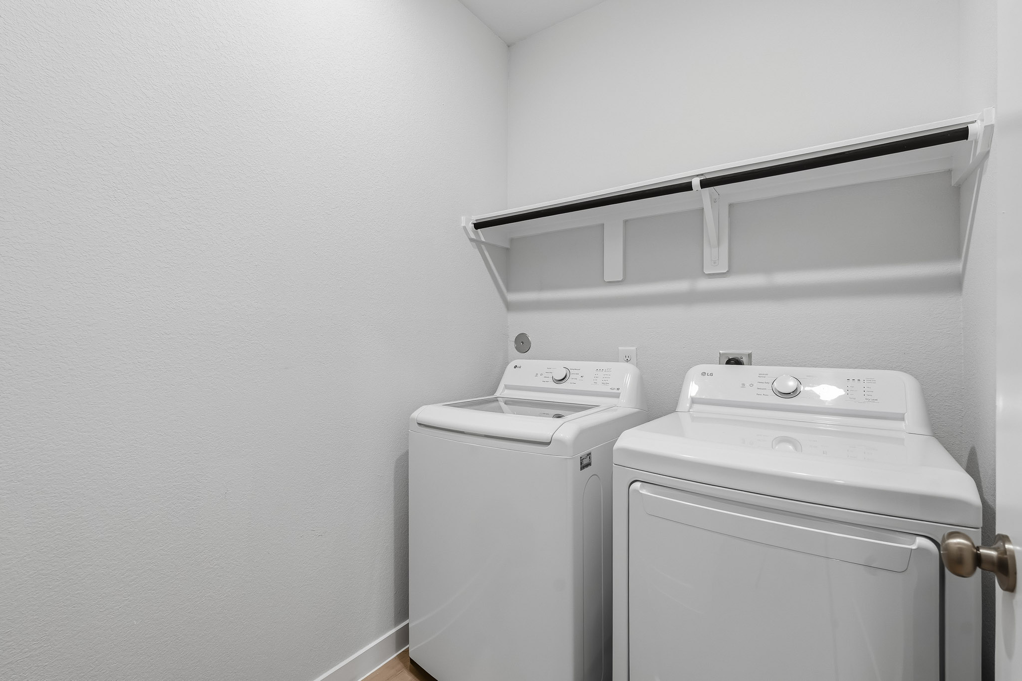 A white washing machine and a white wall.