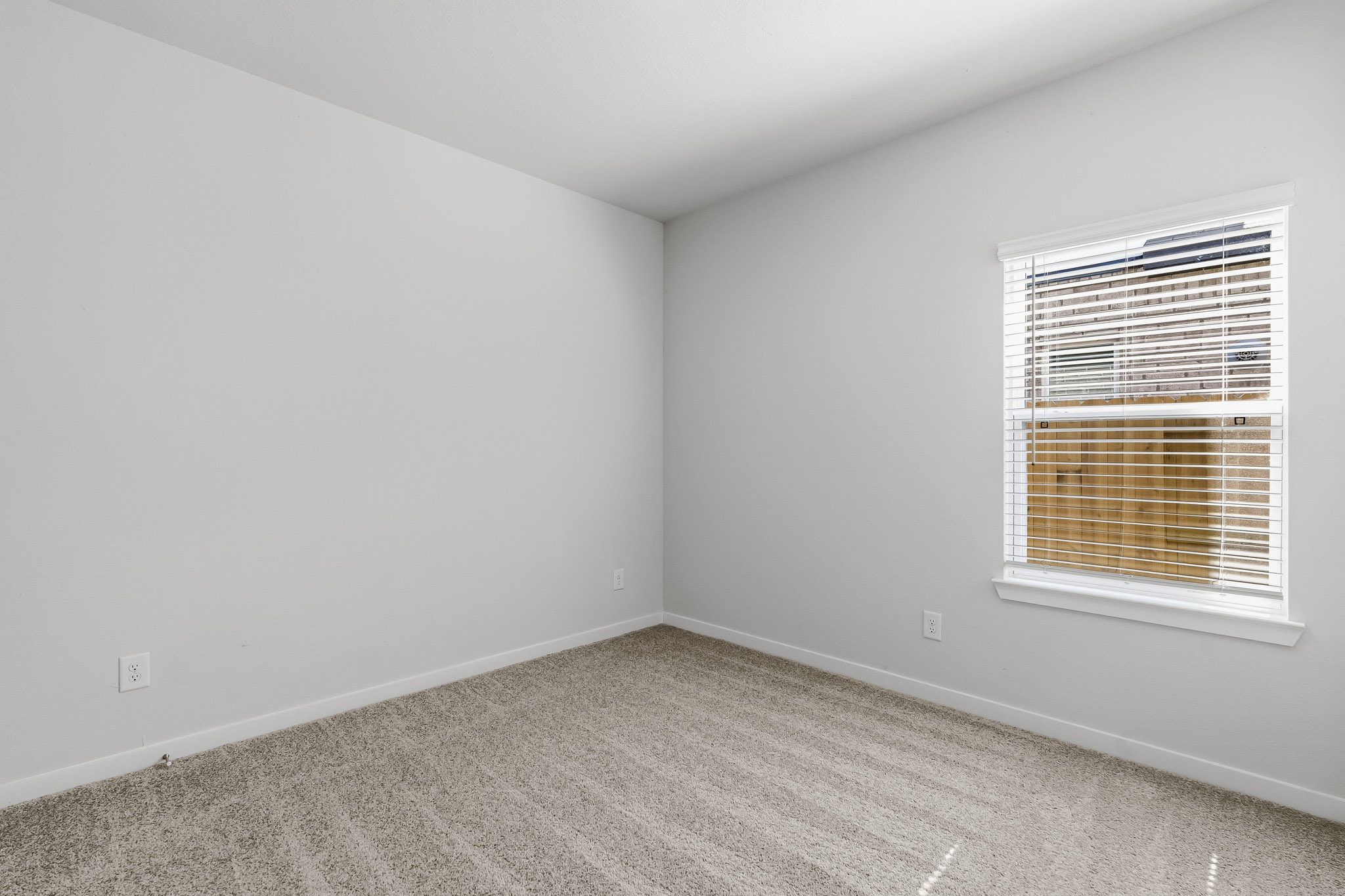 A room with a window and carpet.