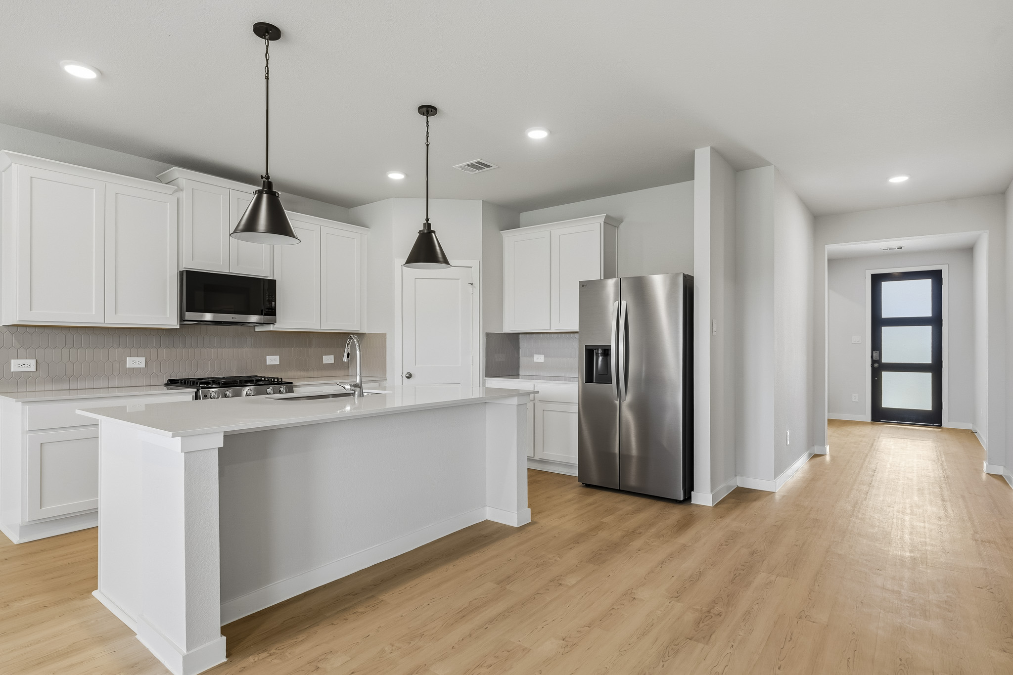 A kitchen with white cabinets.
