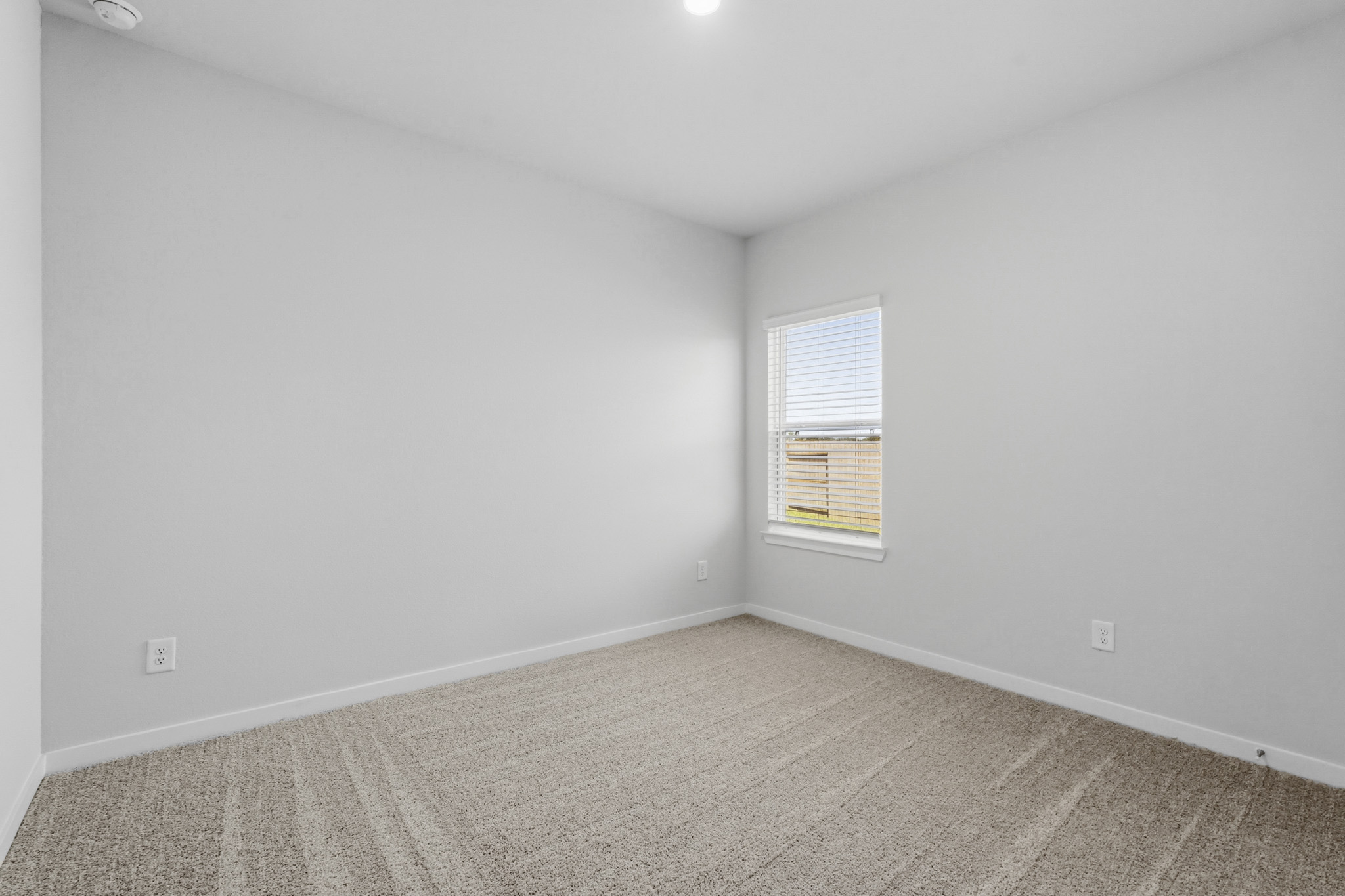 A room with a window and a carpet.