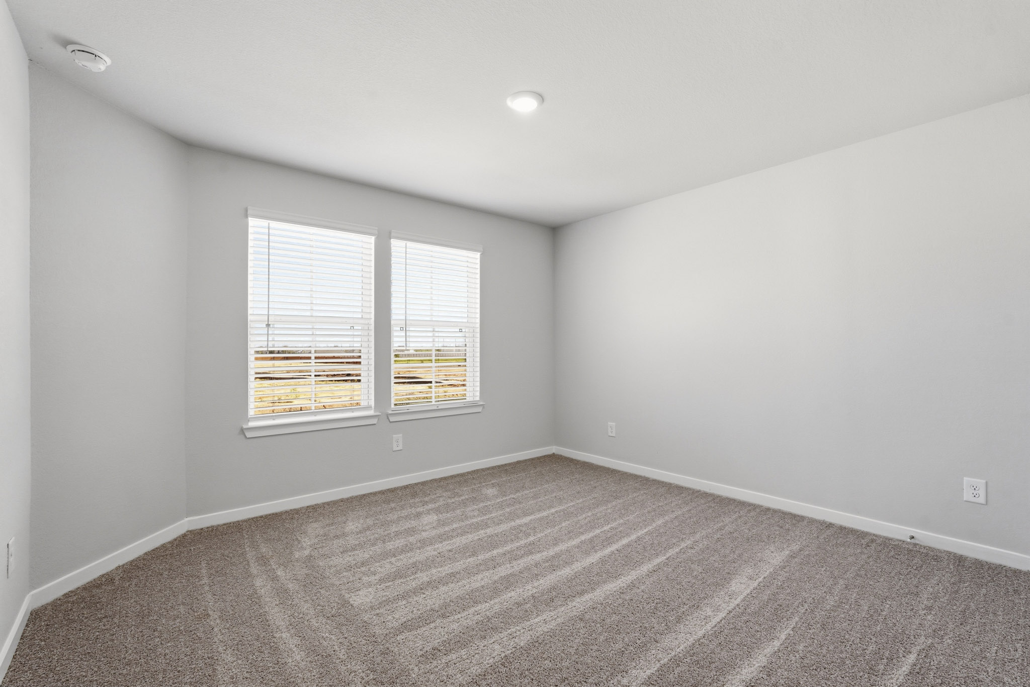 A room with a window and a rug.