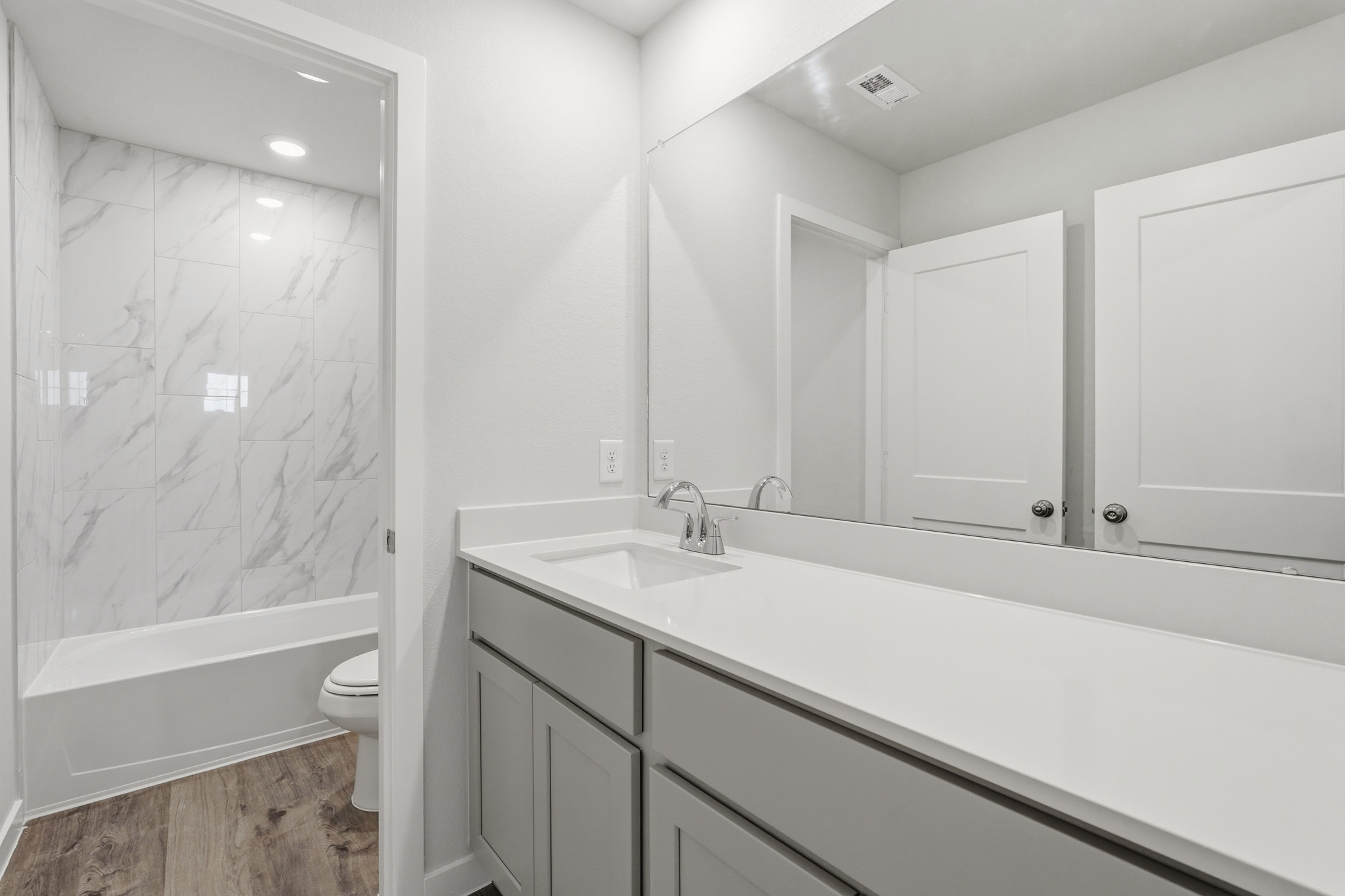 A bathroom with a tub sink and toilet.