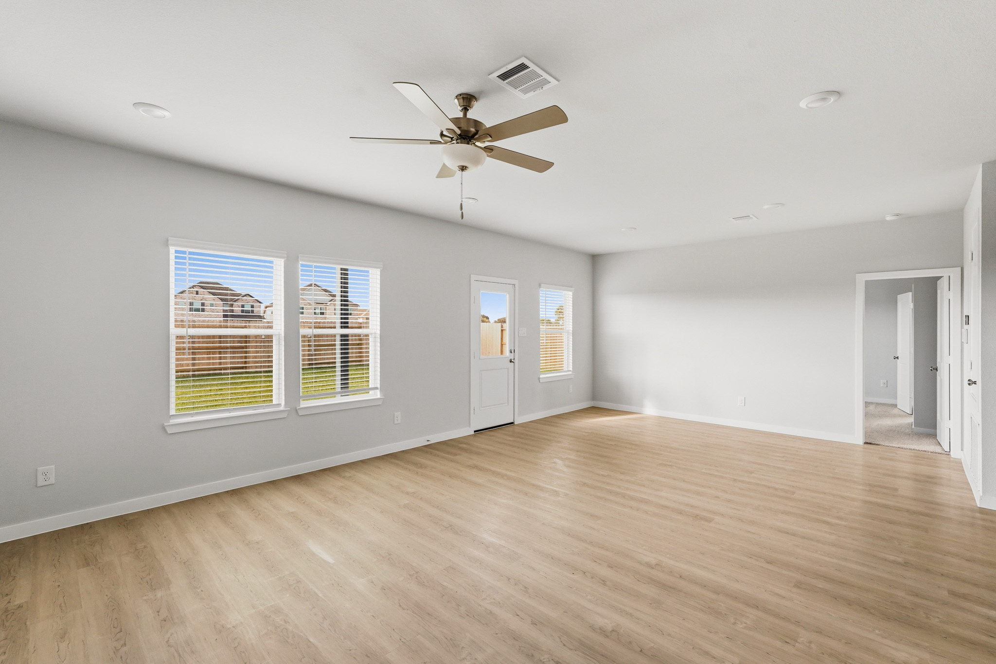 A room with a wood floor and a ceiling fan.