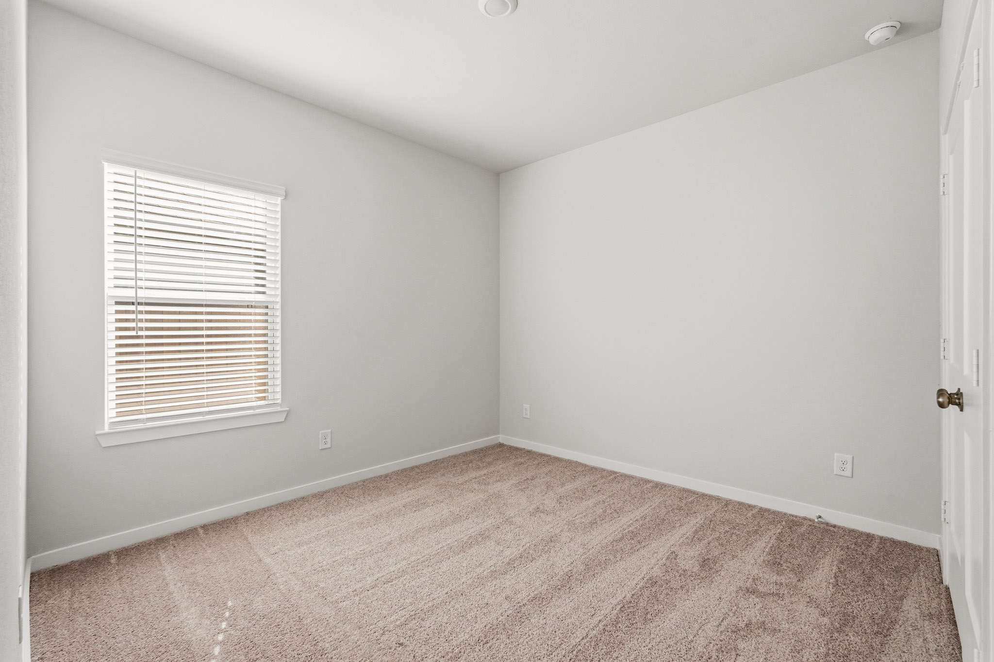 A room with a carpet and a window.