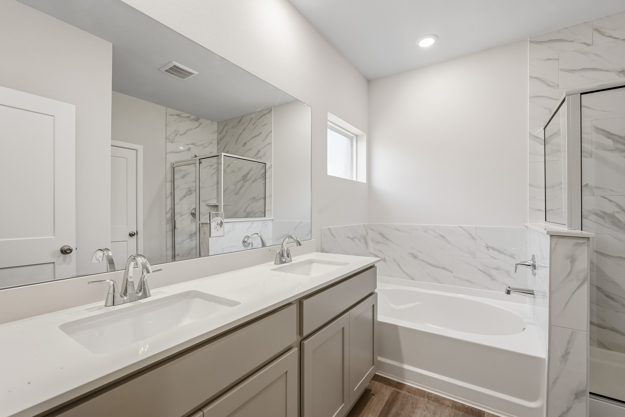 A bathroom with a tub sink and a mirror.