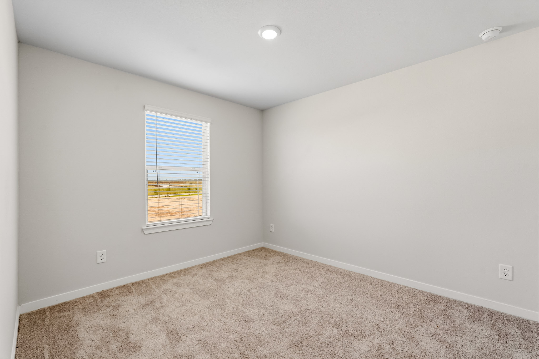 A room with a window and carpet.