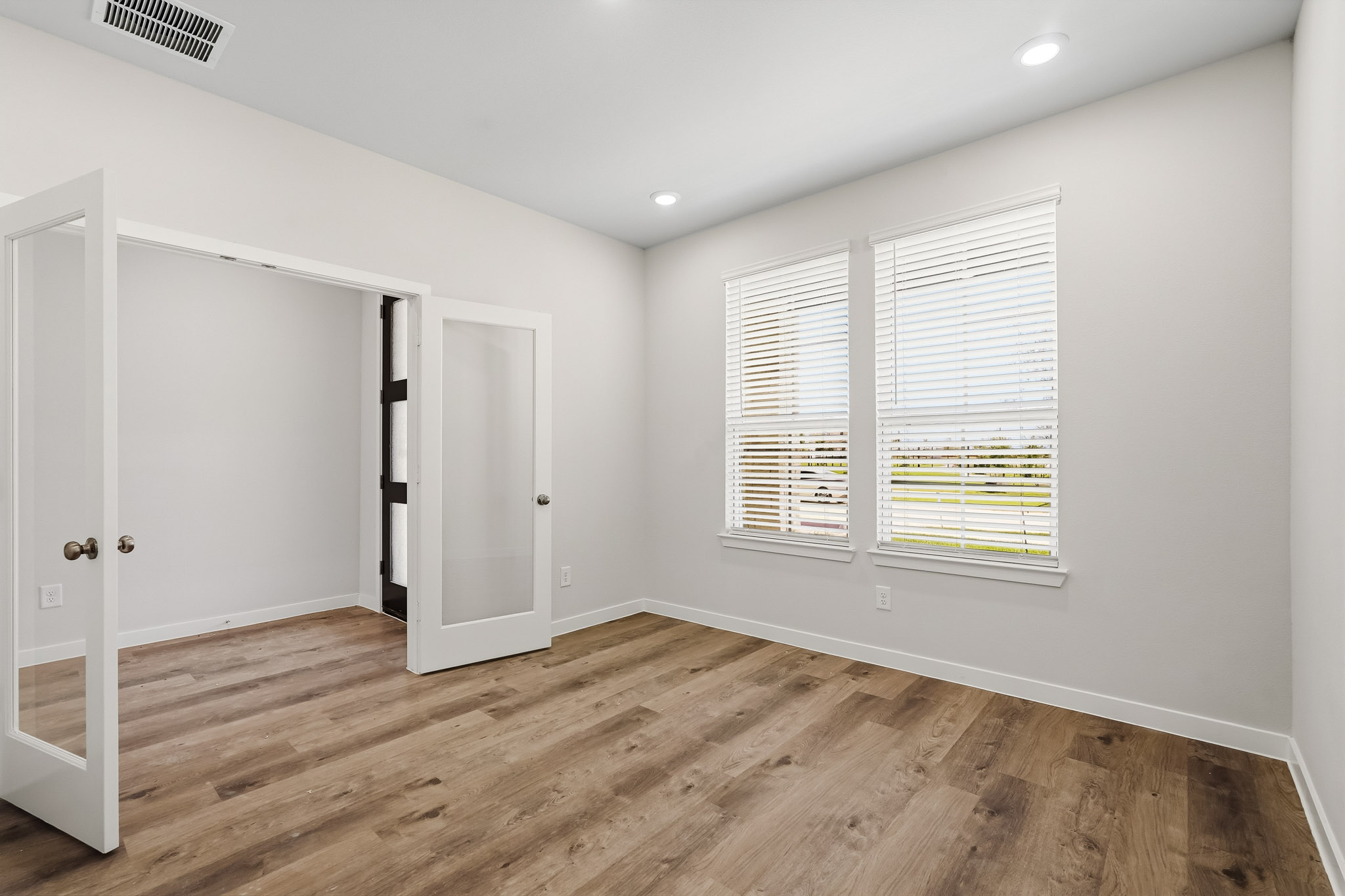 A room with a wood floor and white walls.