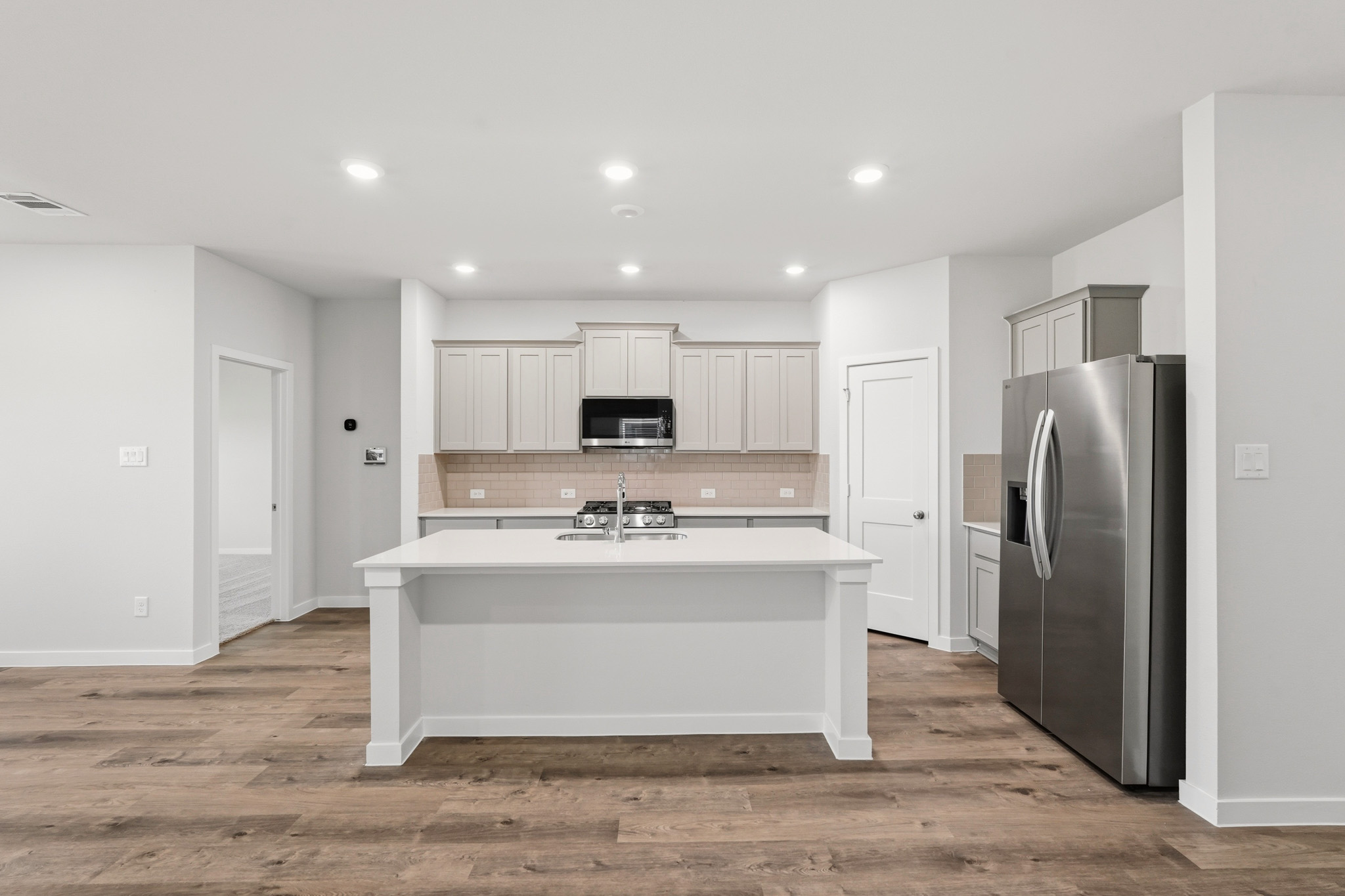 A kitchen with white cabinets.