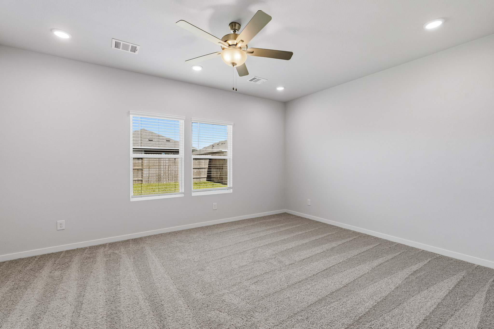 A room with a ceiling fan and a window.
