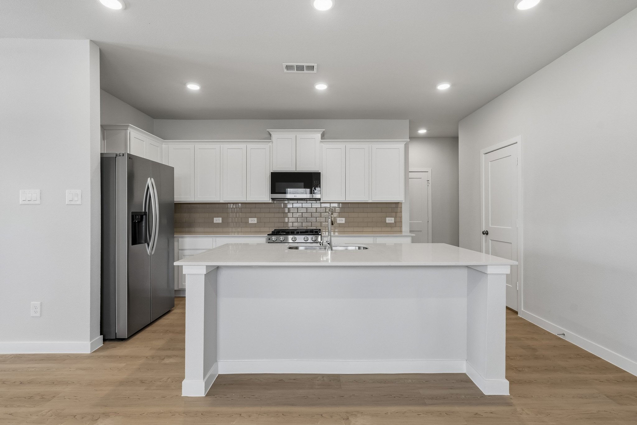 A kitchen with white cabinets.