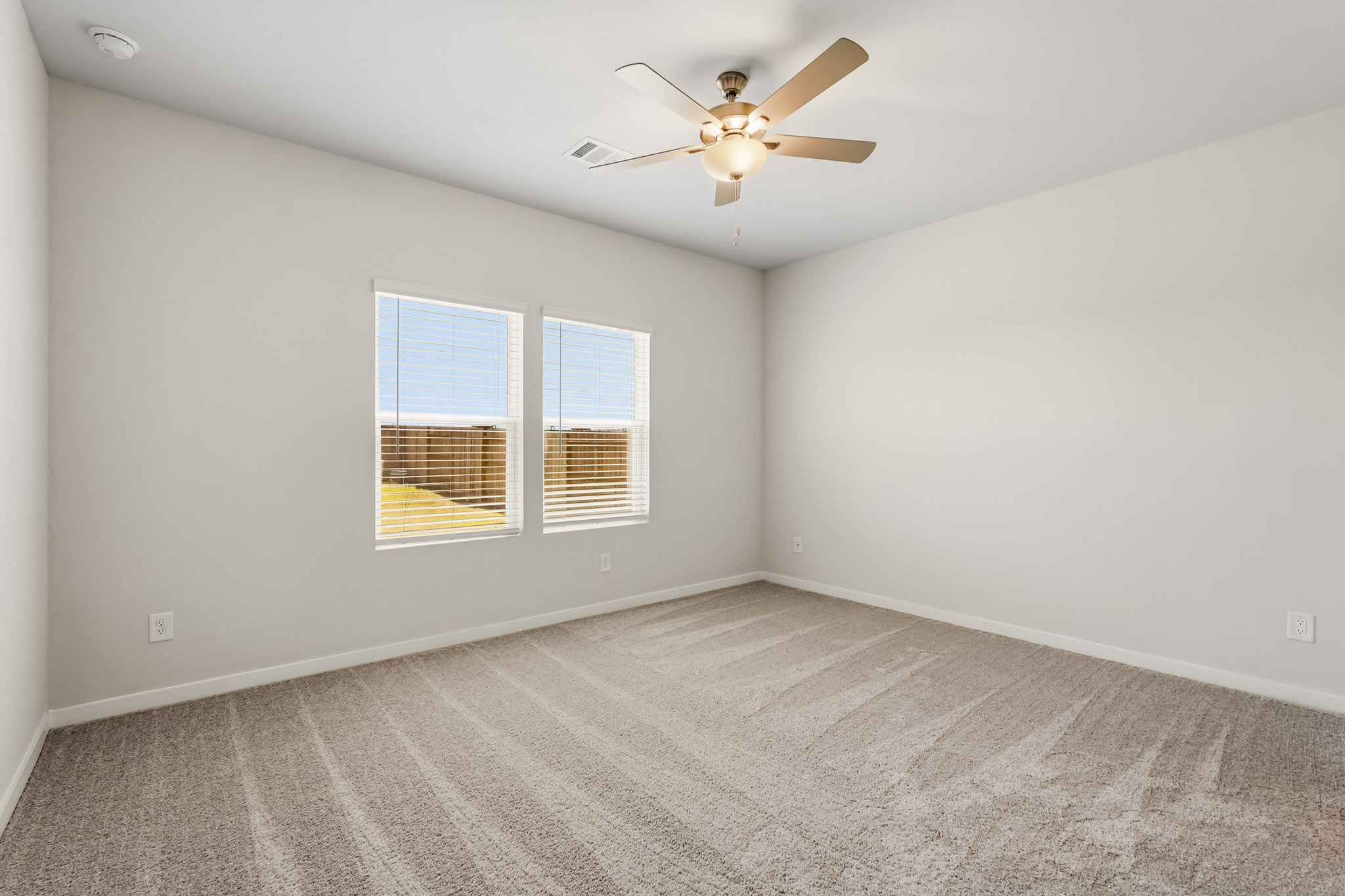 A room with a ceiling fan and a window.