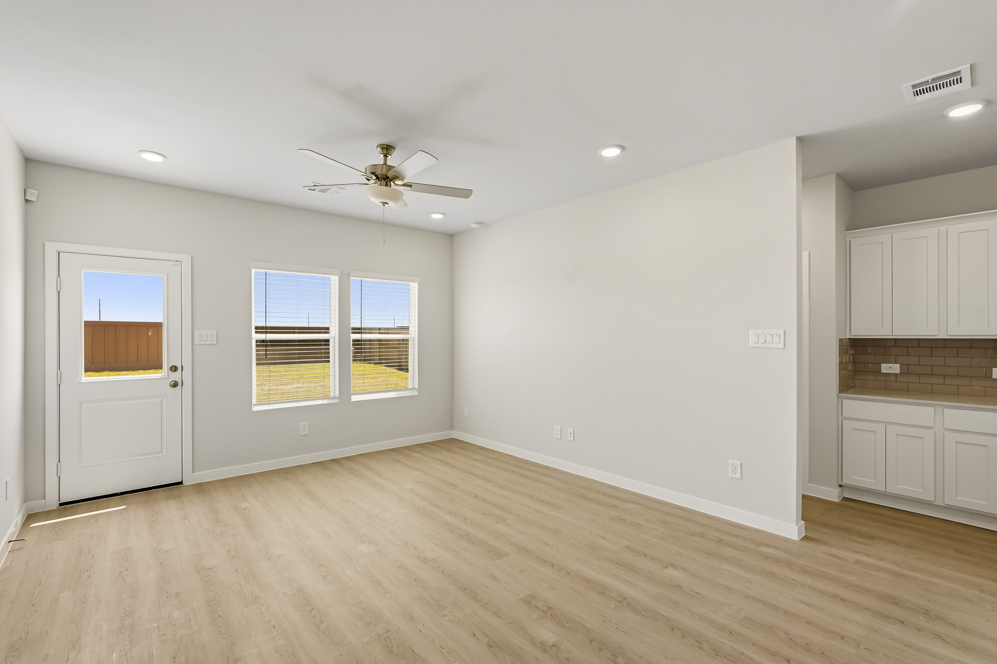 A room with white walls and a ceiling fan.