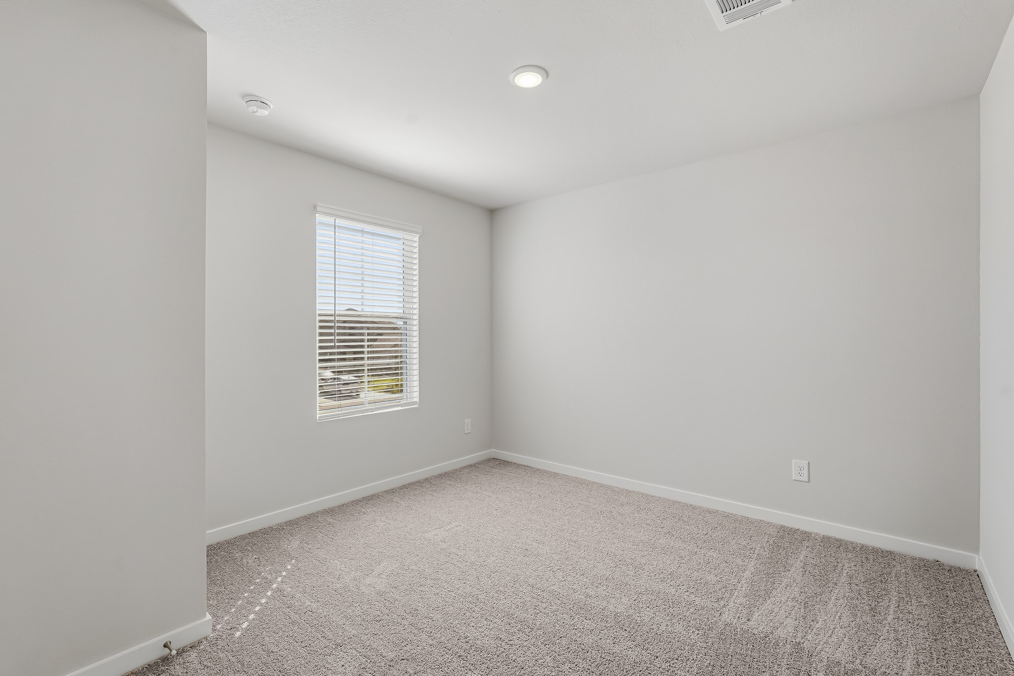 A room with a carpet and a window.