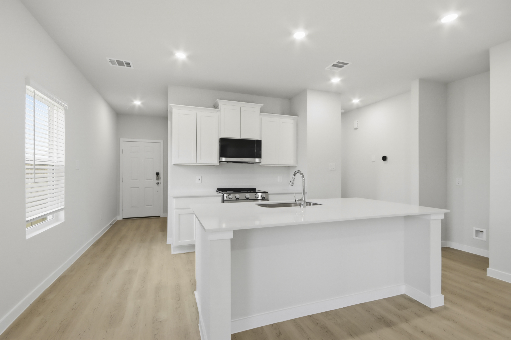 A kitchen with white cabinets.