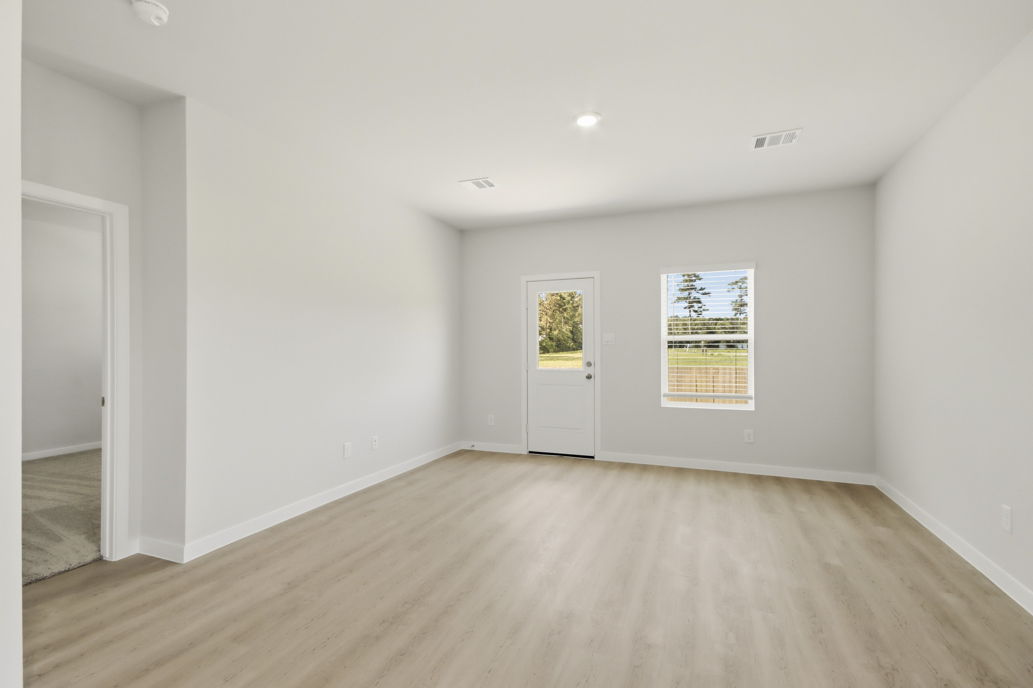 A room with a wood floor and white walls.