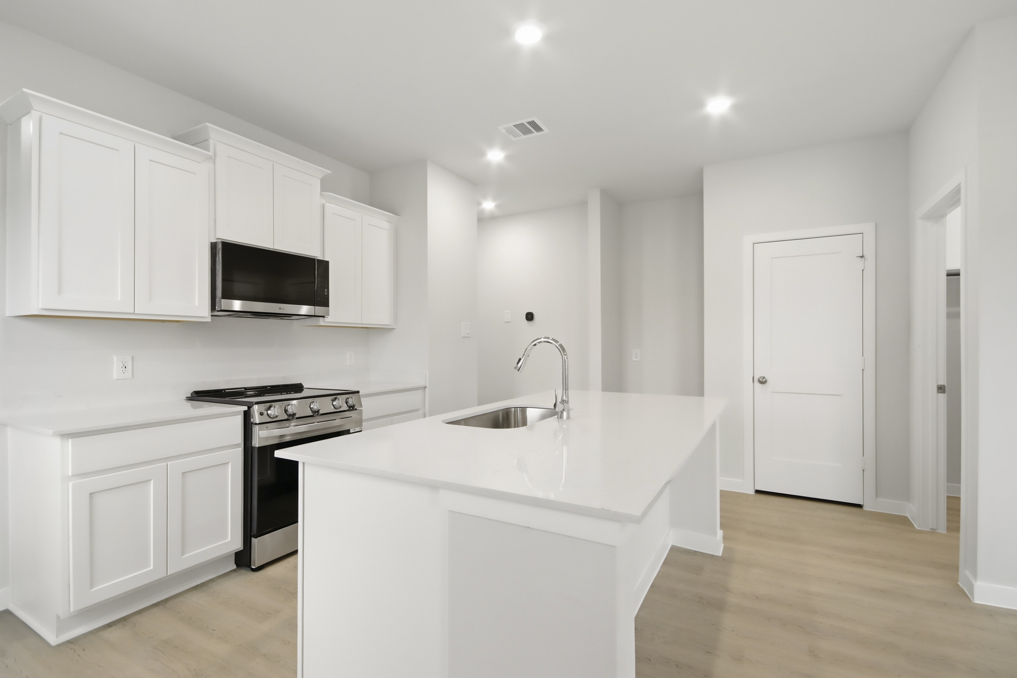 A kitchen with white cabinets.