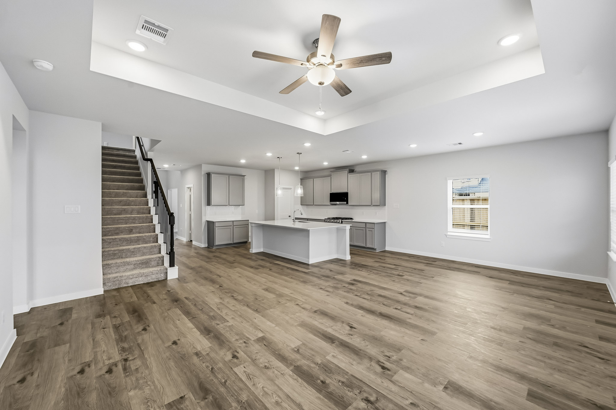 A large empty room with a wood floor and a wood floor.