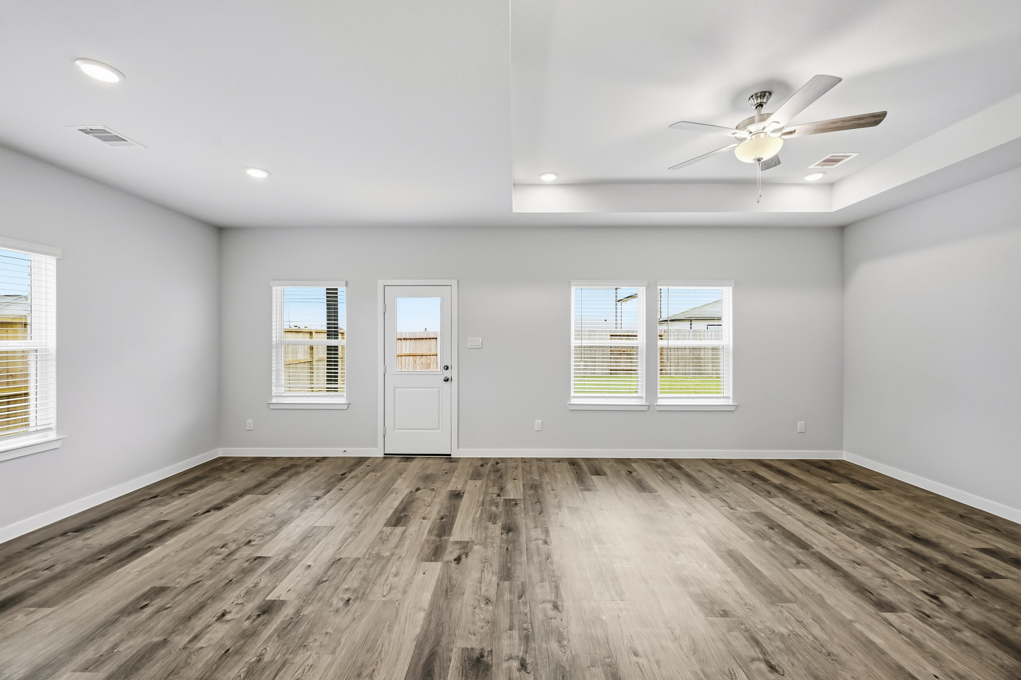 A room with a wood floor and a ceiling fan.