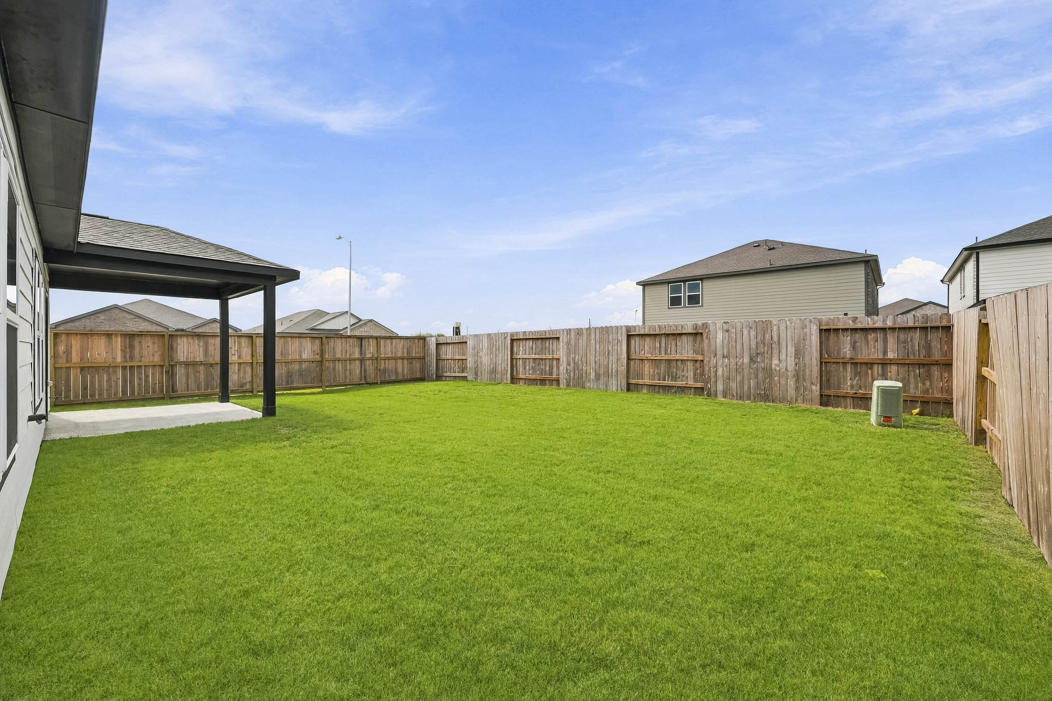 A fenced in yard with a house in the background.