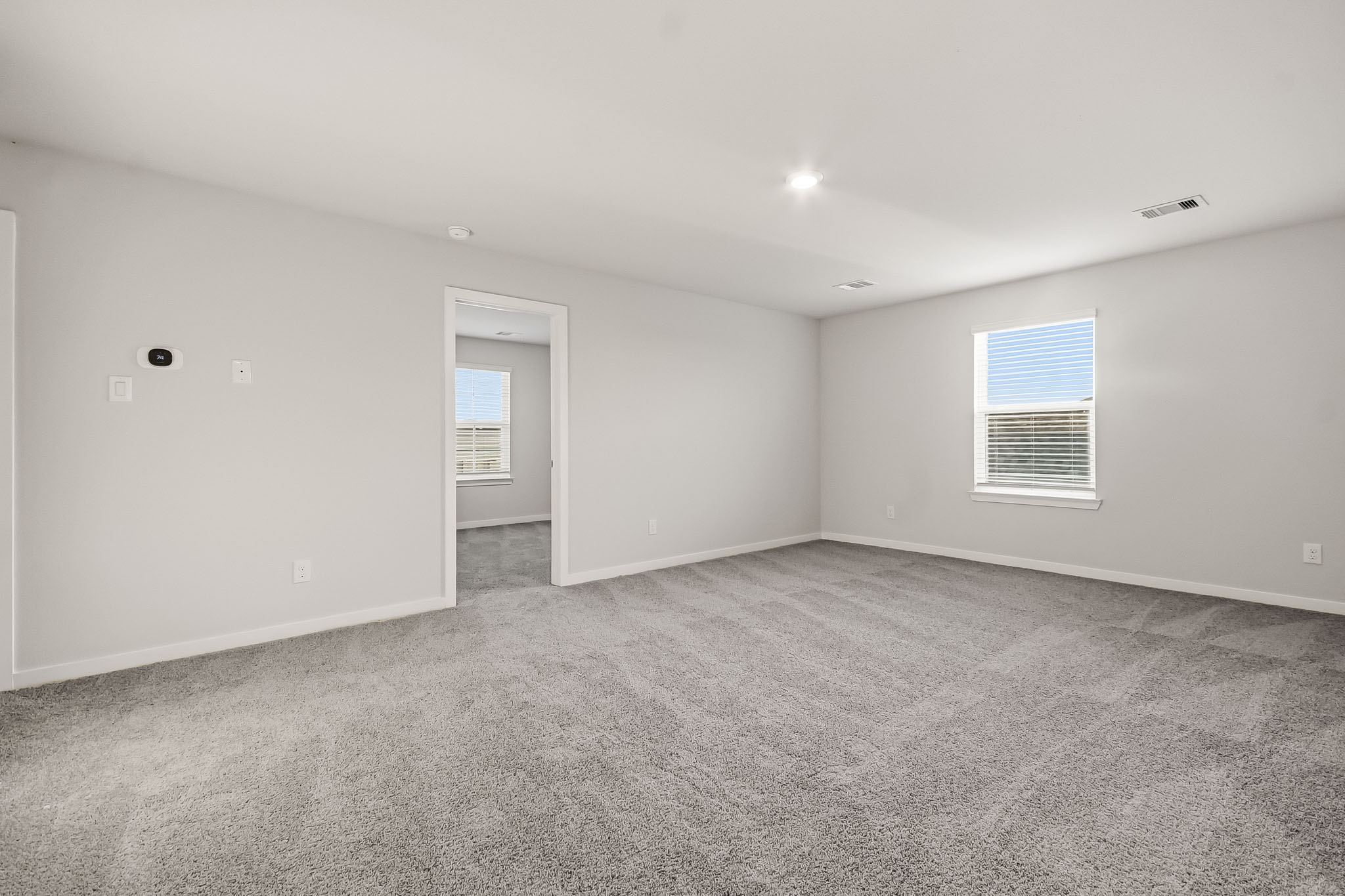 A room with a carpet and a door.