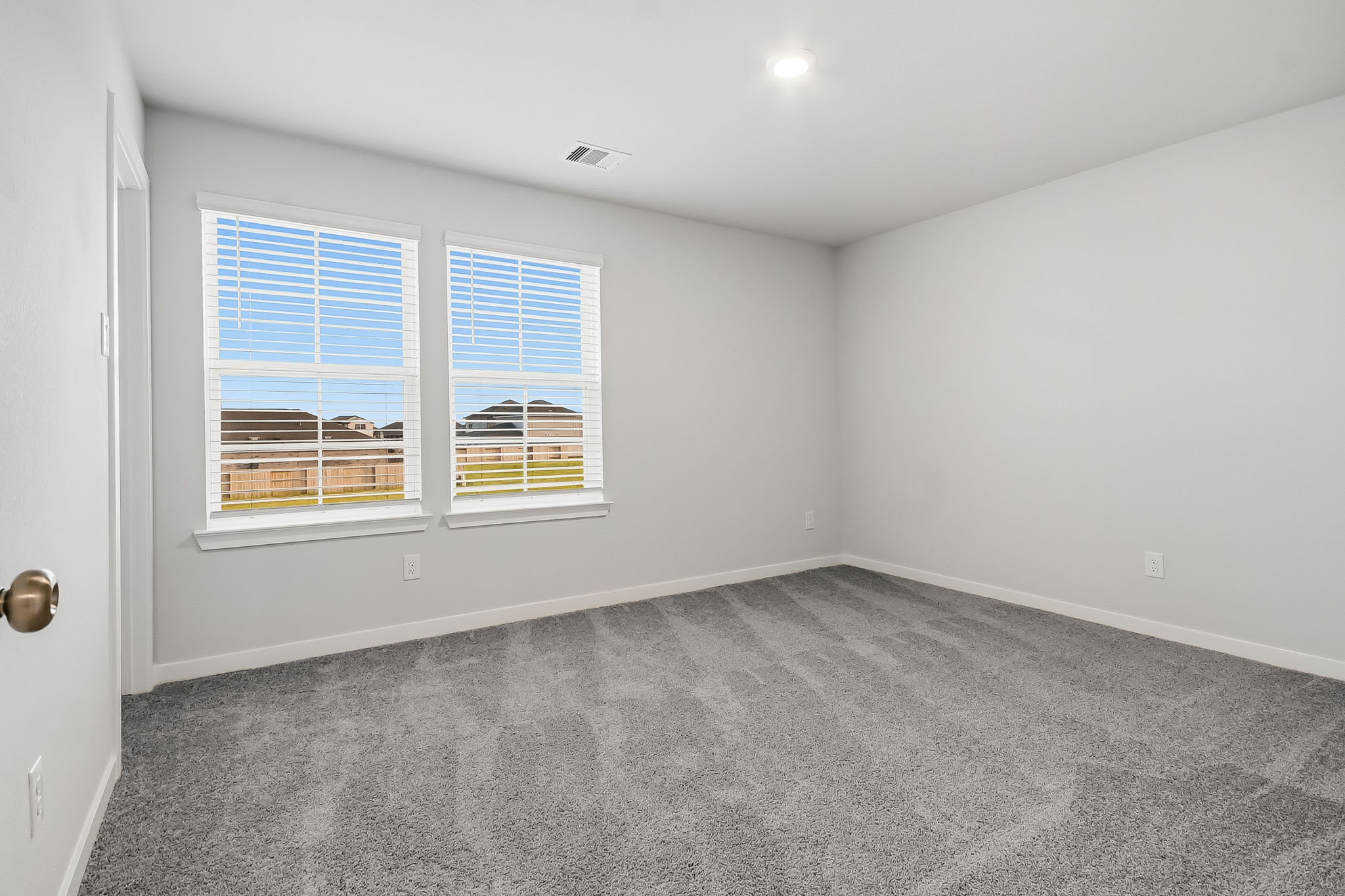 A room with a window and a carpet.