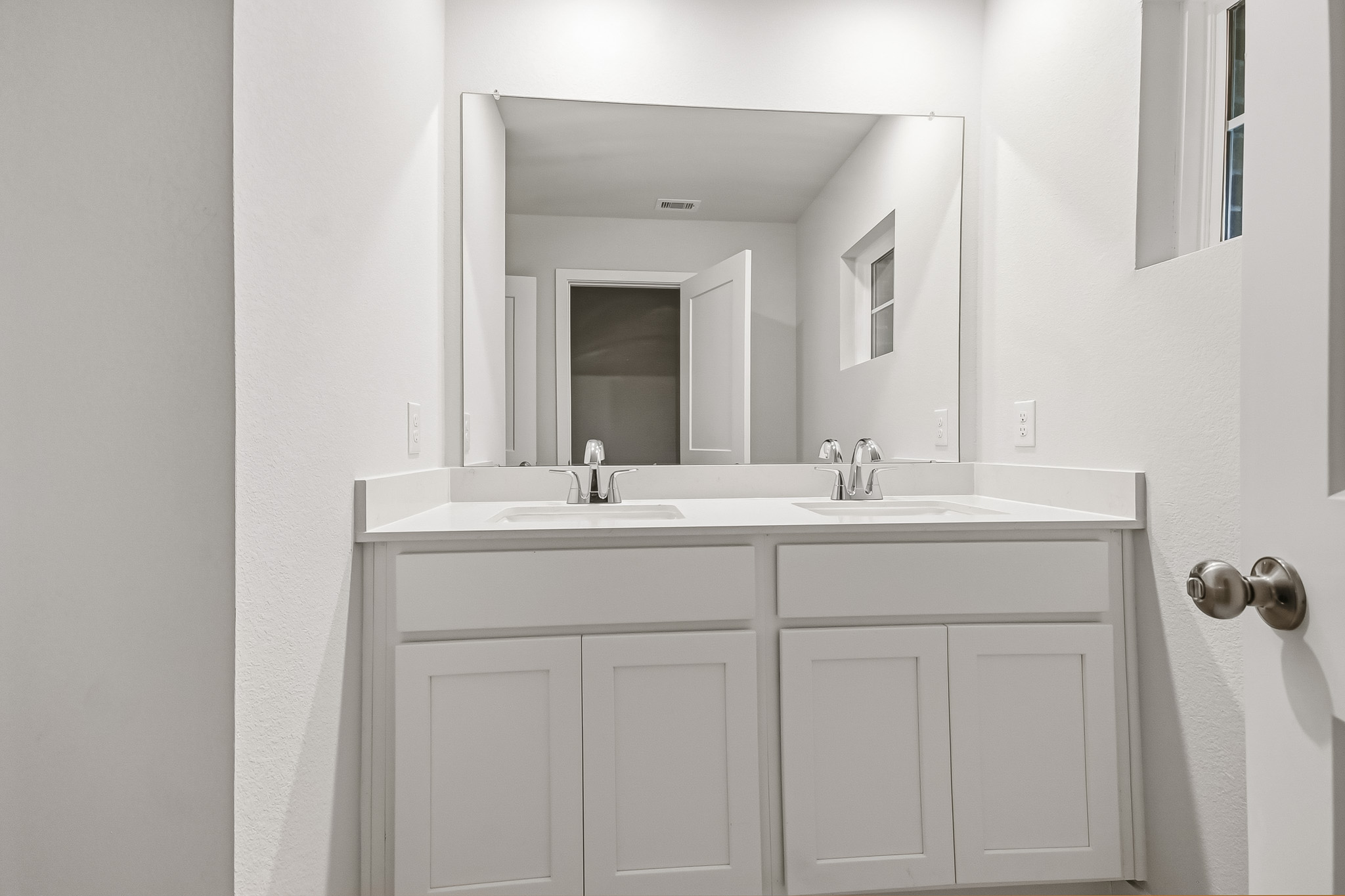 A bathroom with white cabinets.