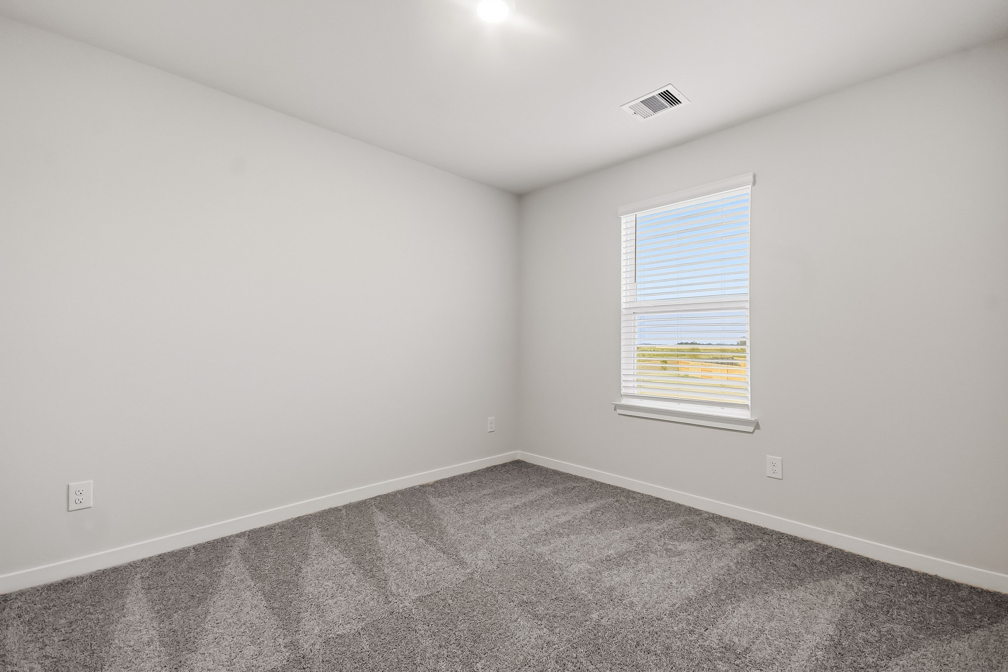 A room with a window and carpet.