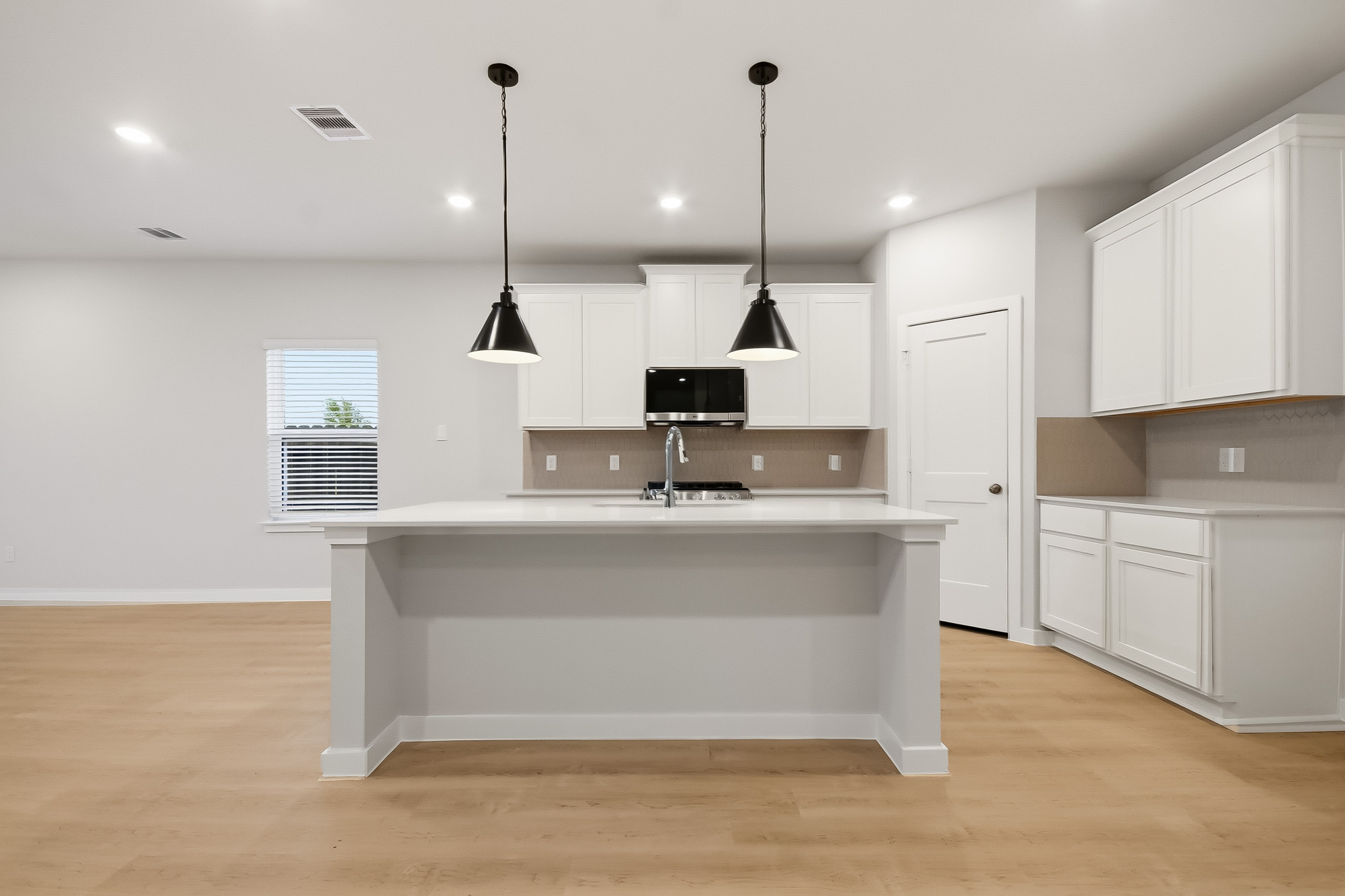 A kitchen with white cabinets.