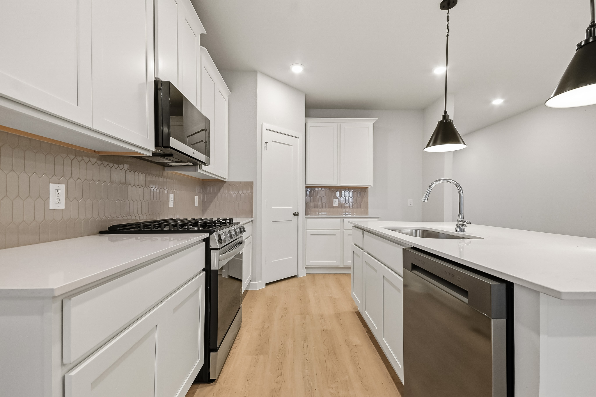A kitchen with white cabinets.