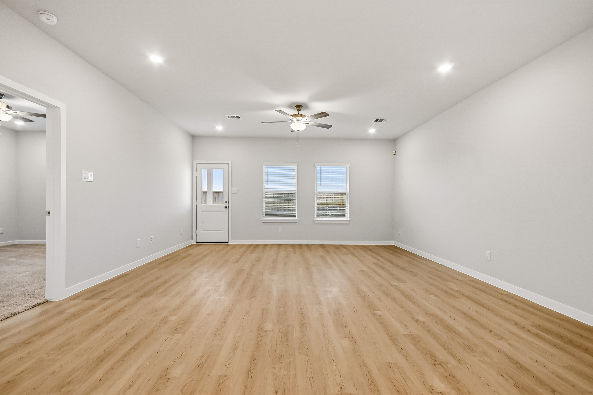 A room with a wood floor and a ceiling fan.
