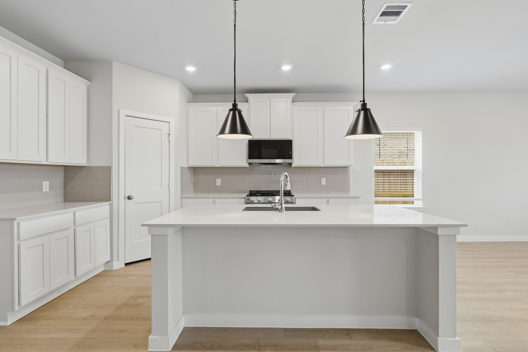 A kitchen with white cabinets.