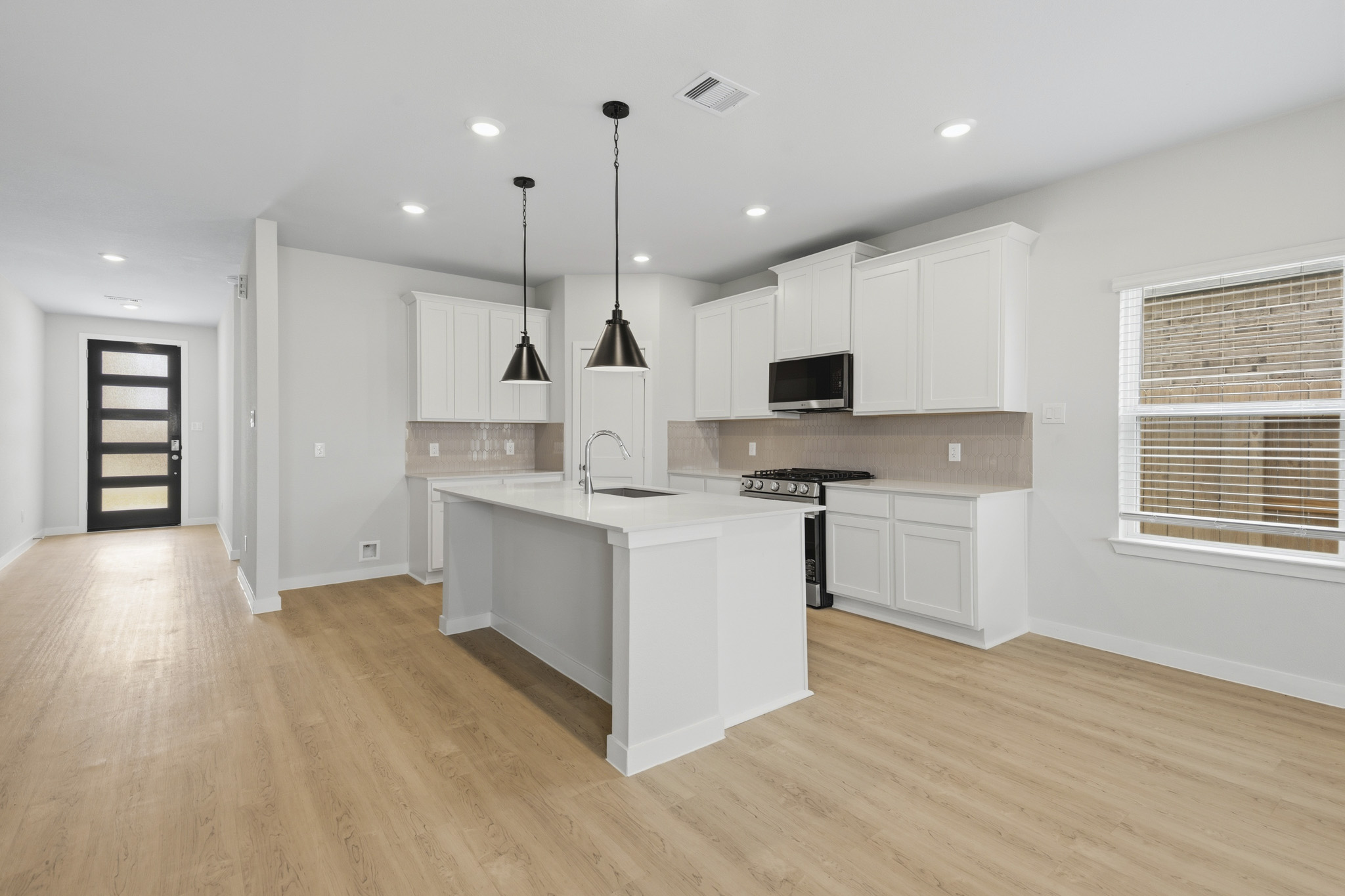 A kitchen with white cabinets.