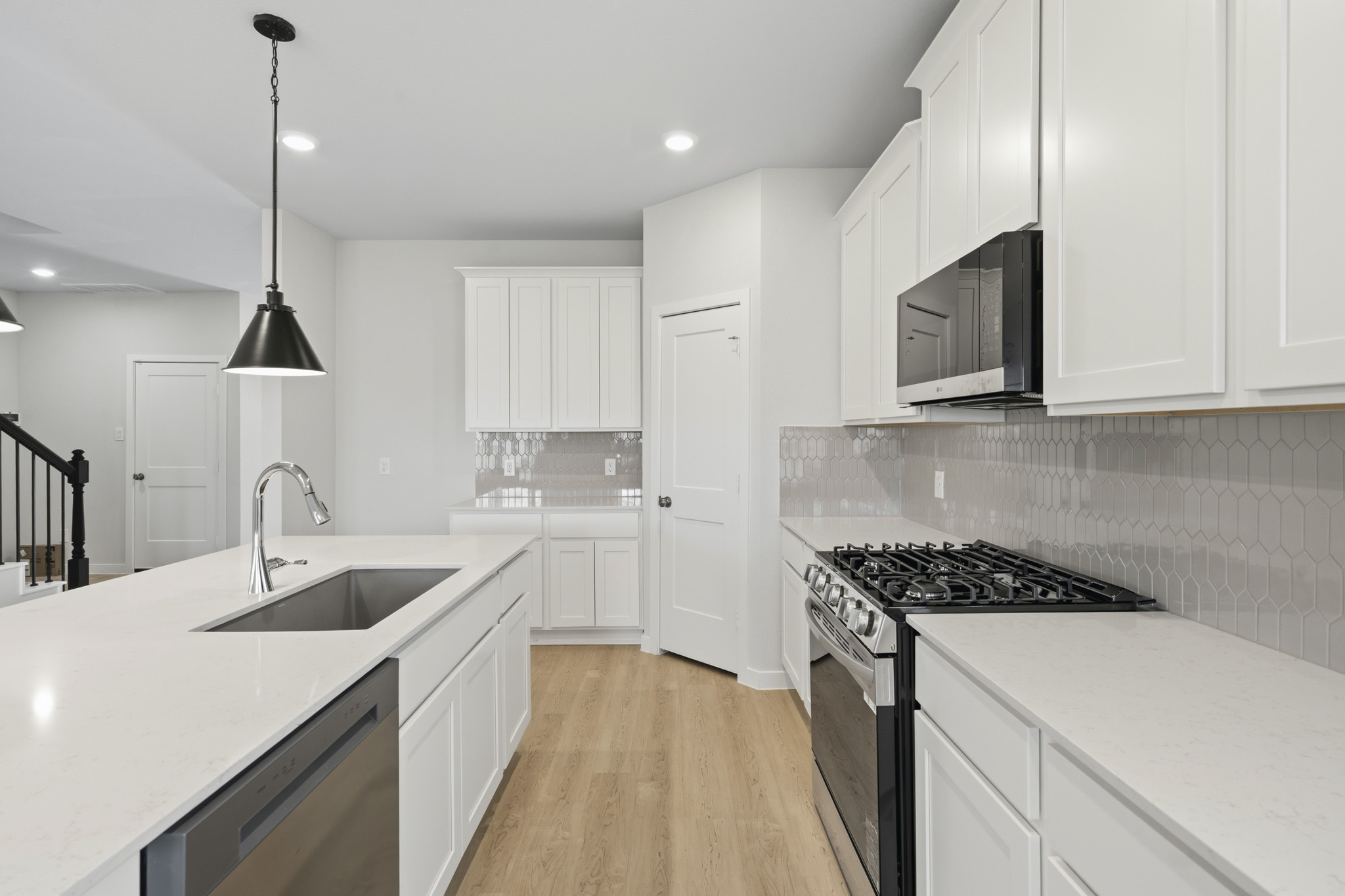 A kitchen with white cabinets.