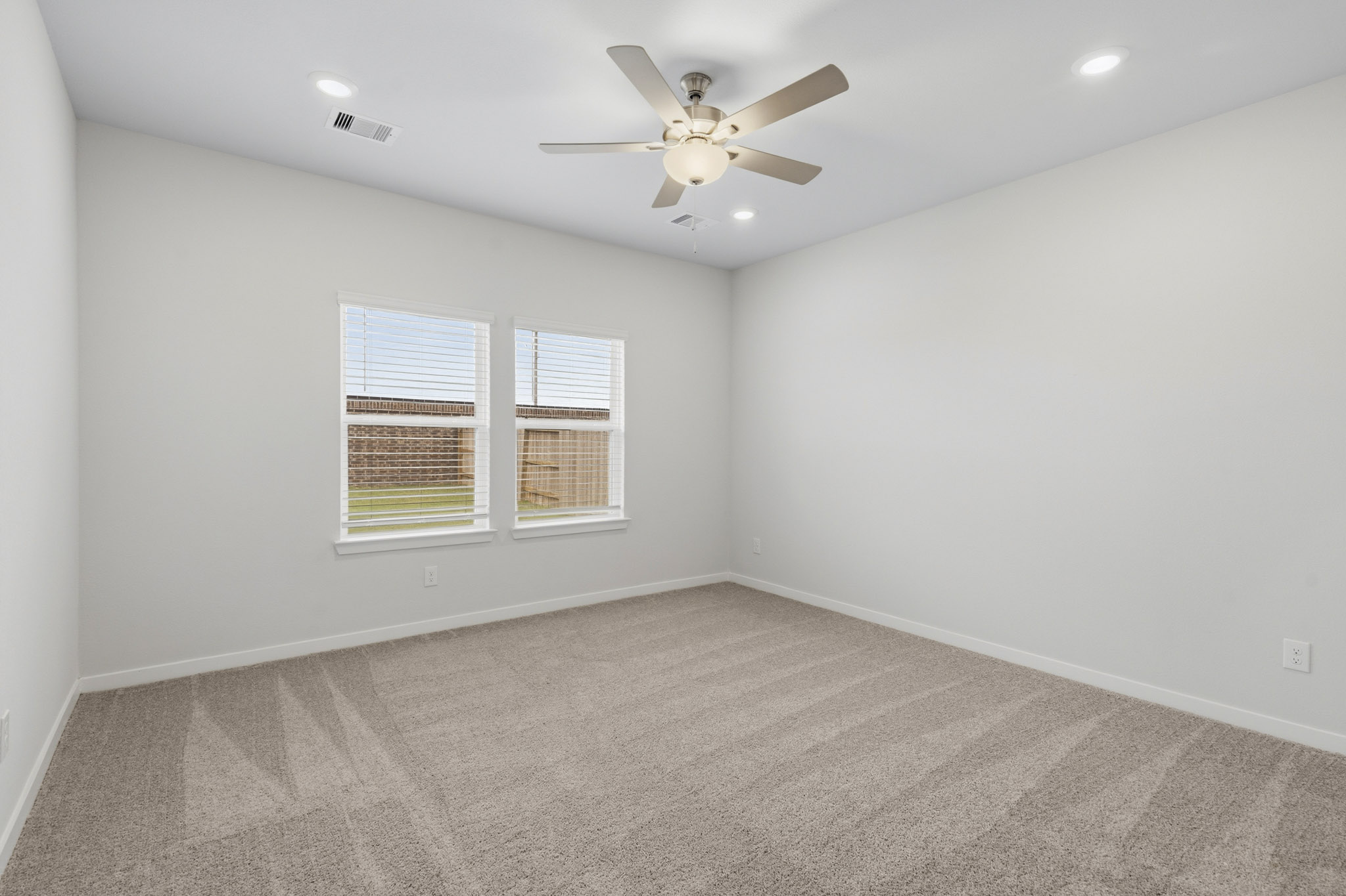 A room with a ceiling fan and a window.