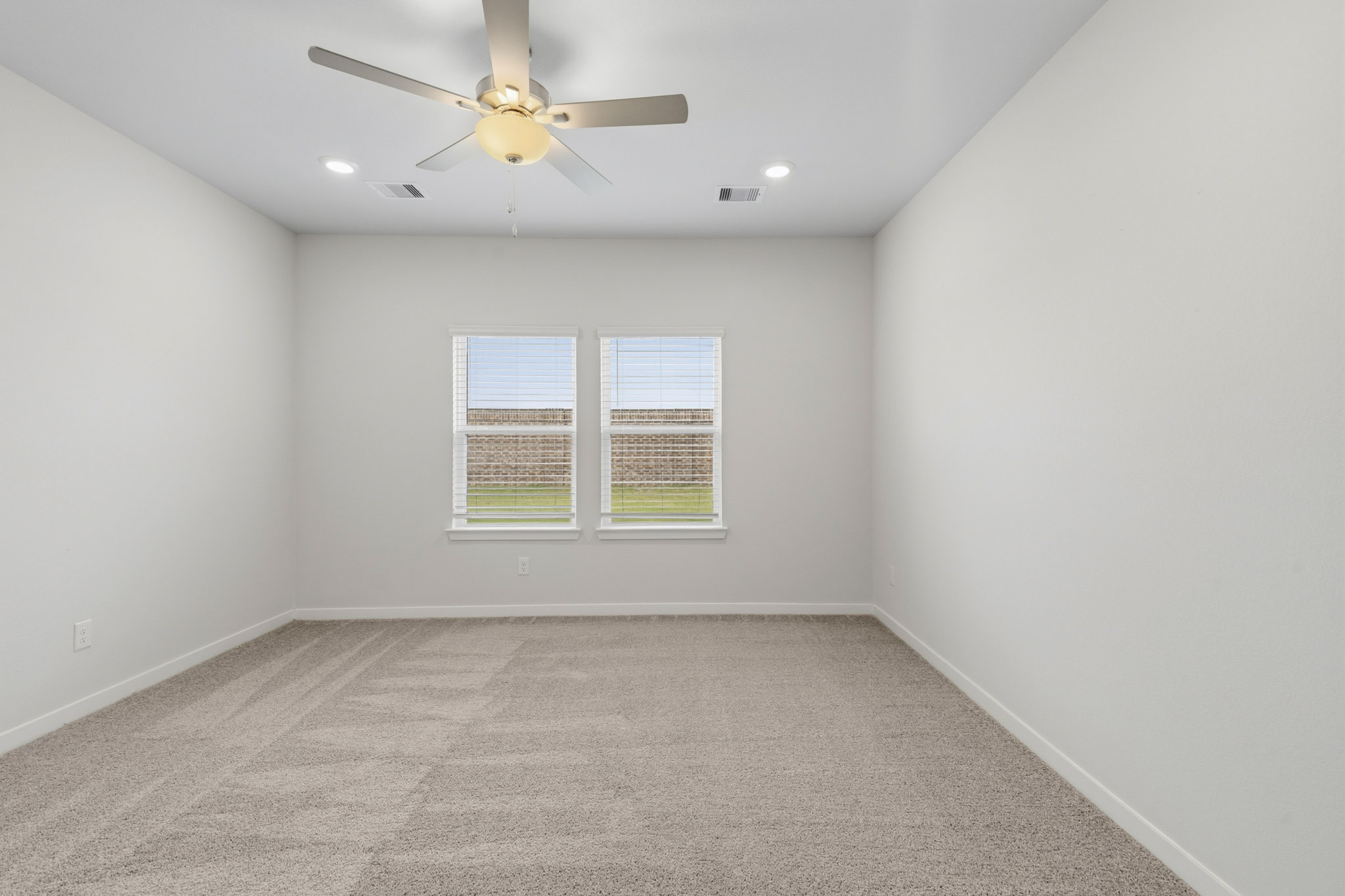 A room with a ceiling fan and a window.