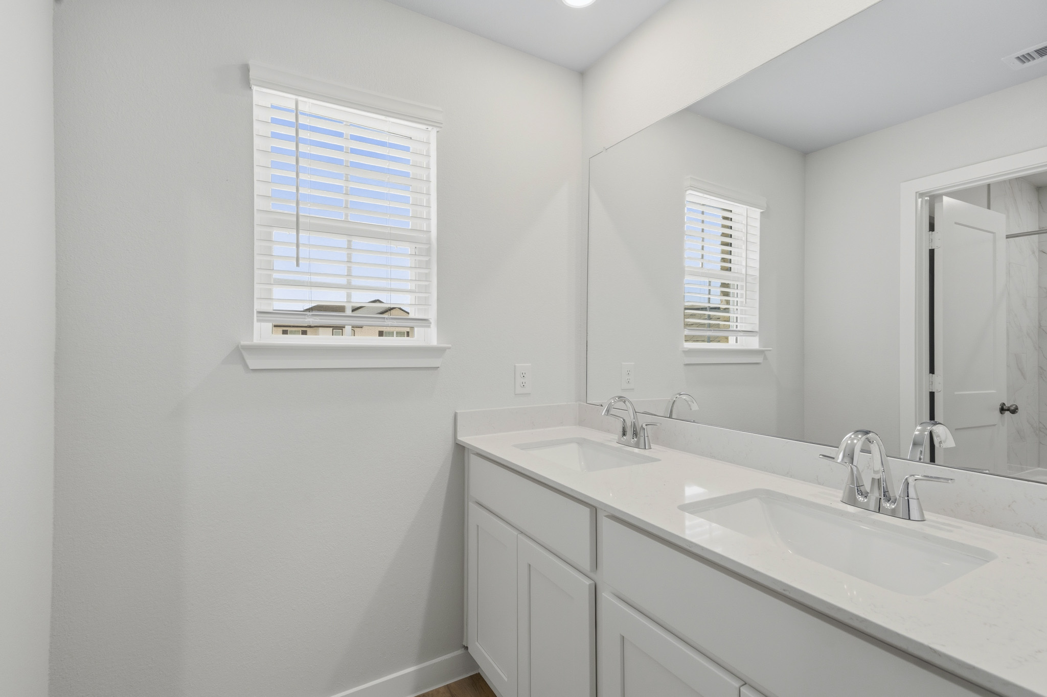 A bathroom with white cabinets.