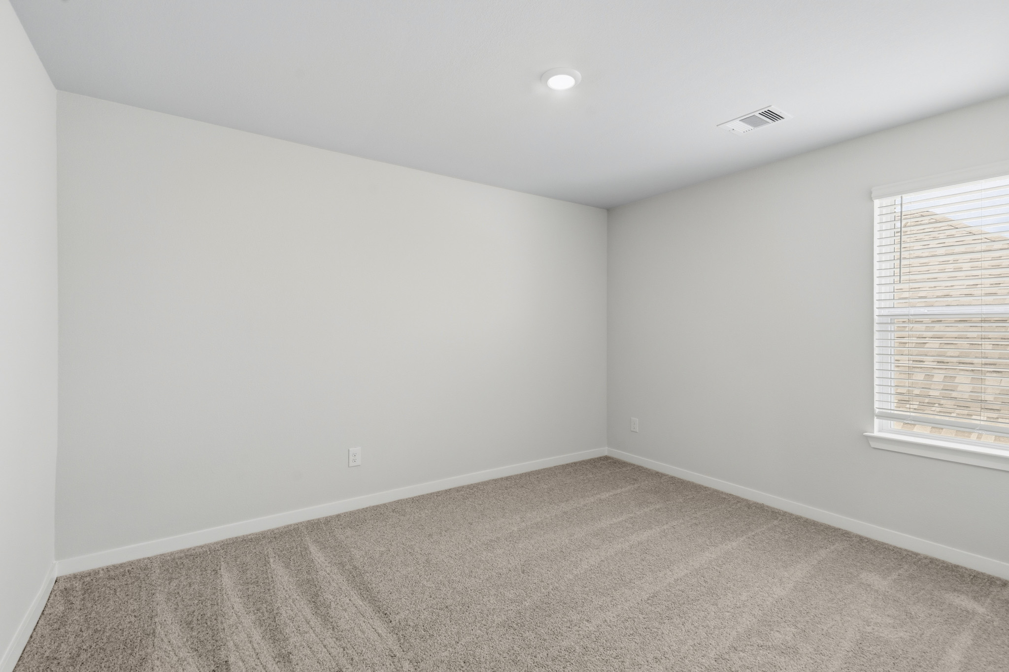 A room with a carpet and a window.