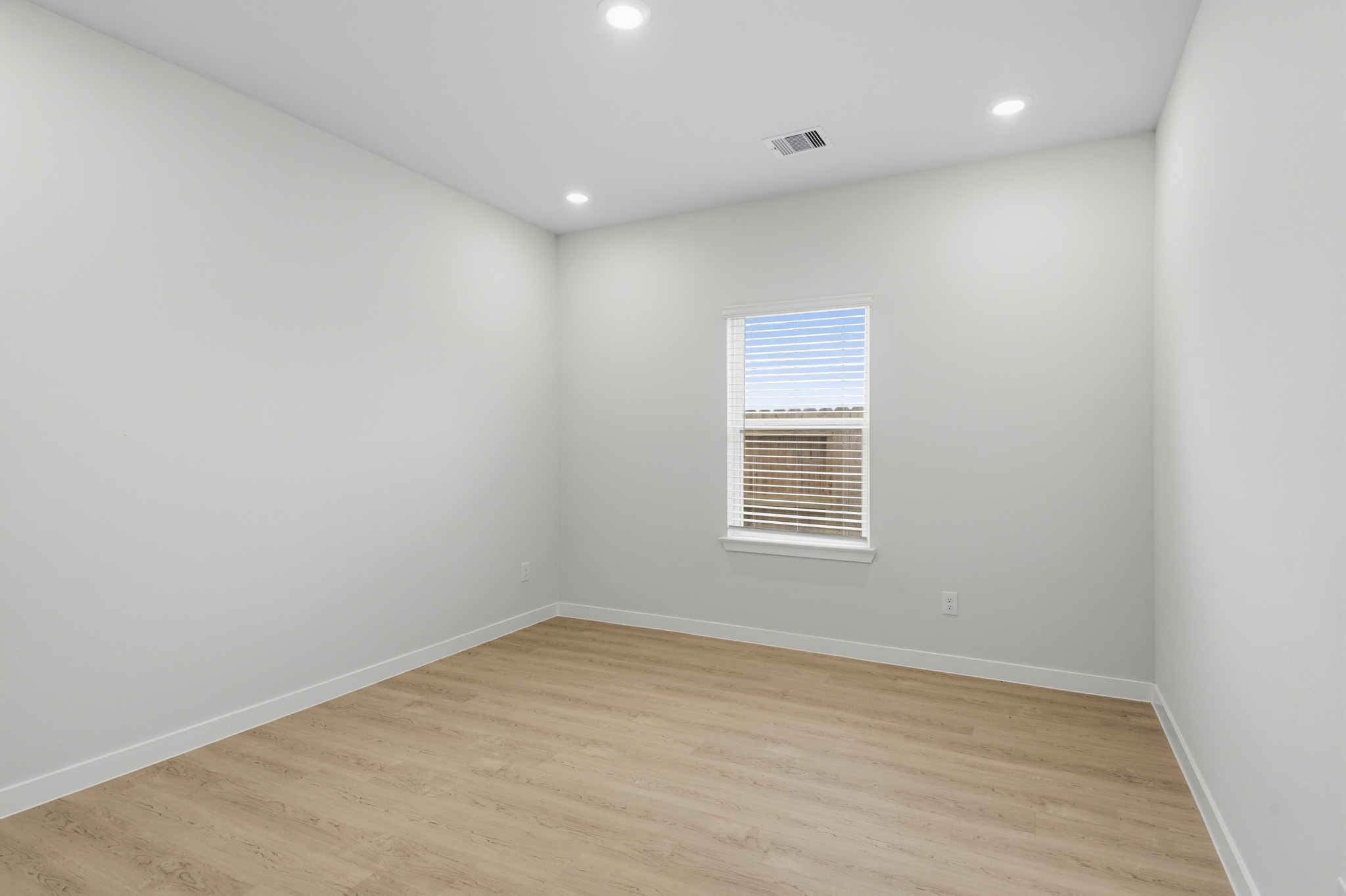 A room with a wood floor and a window.