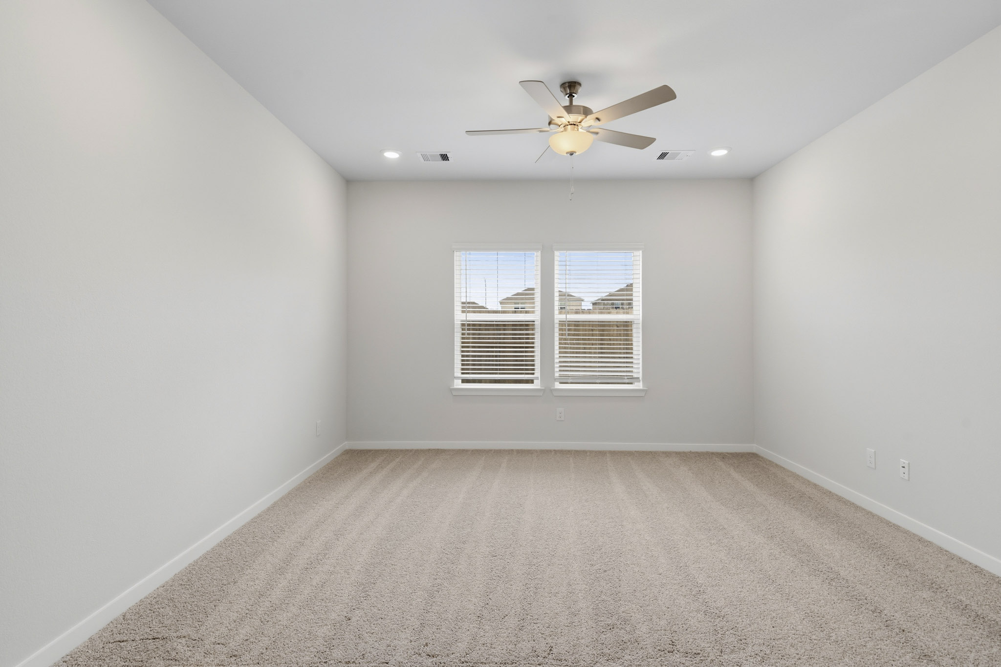 A room with a ceiling fan and a window.