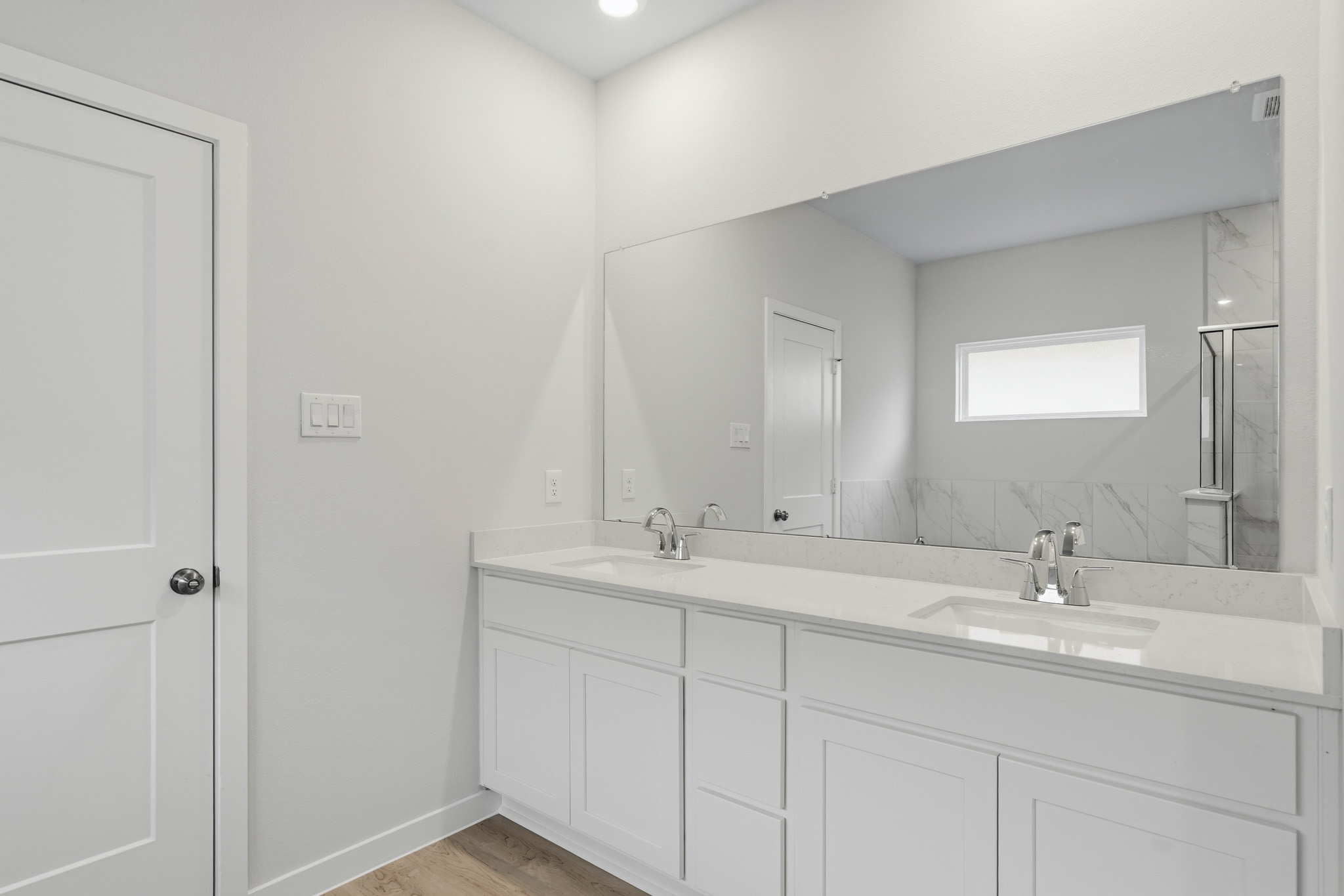A bathroom with white cabinets.