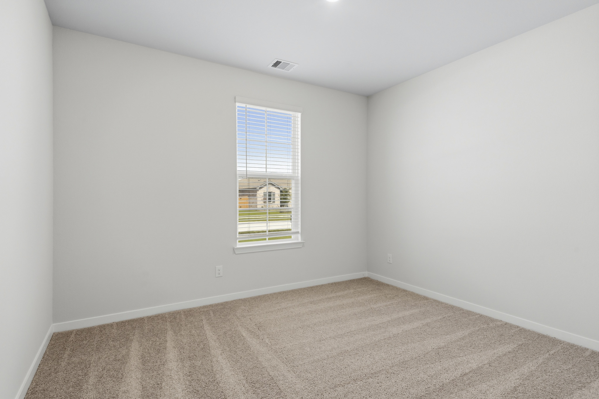 A room with a window and carpet.