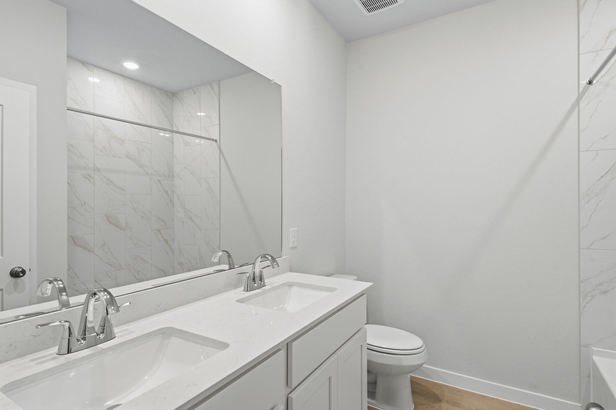 A bathroom with a large mirror.