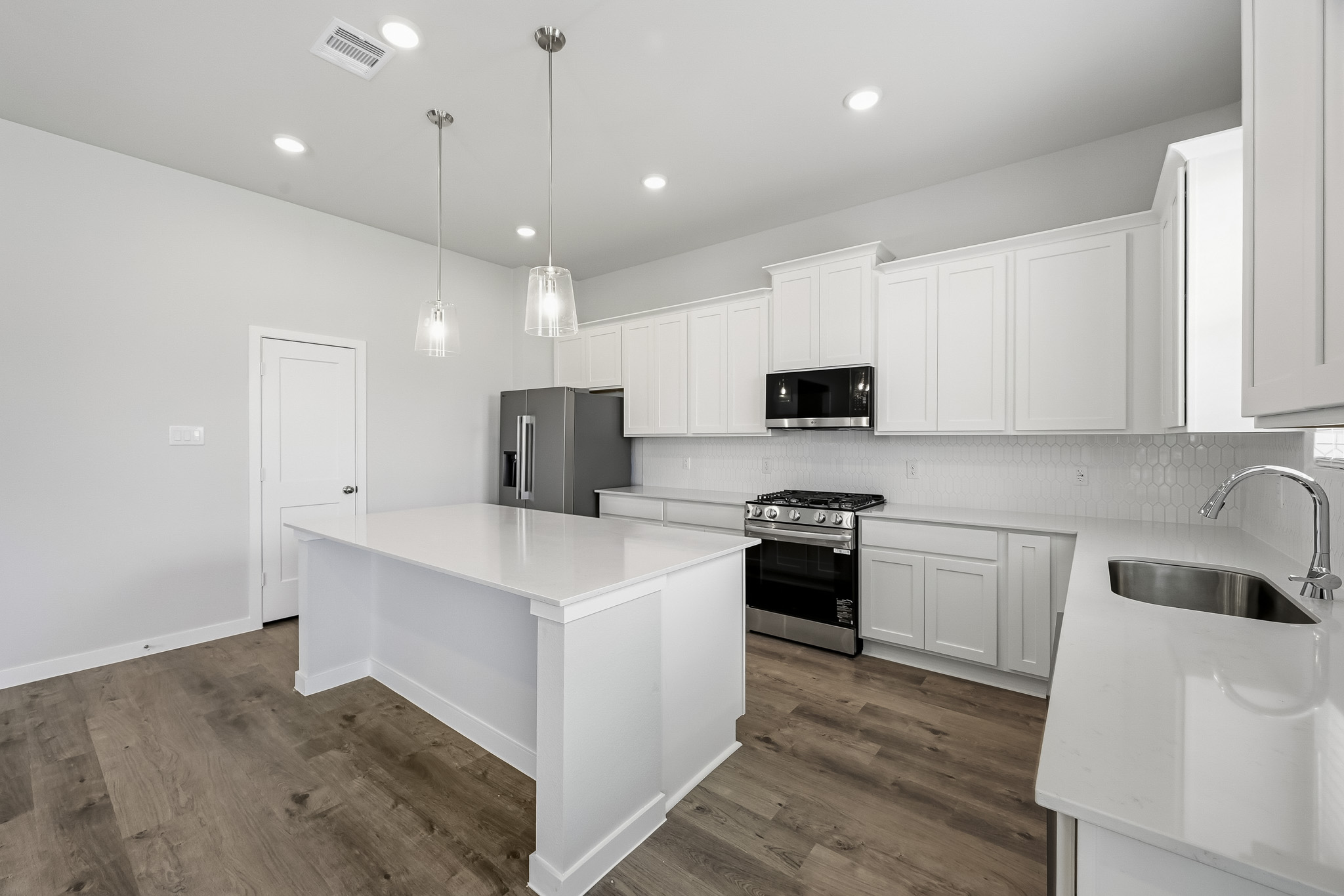 A kitchen with white cabinets.