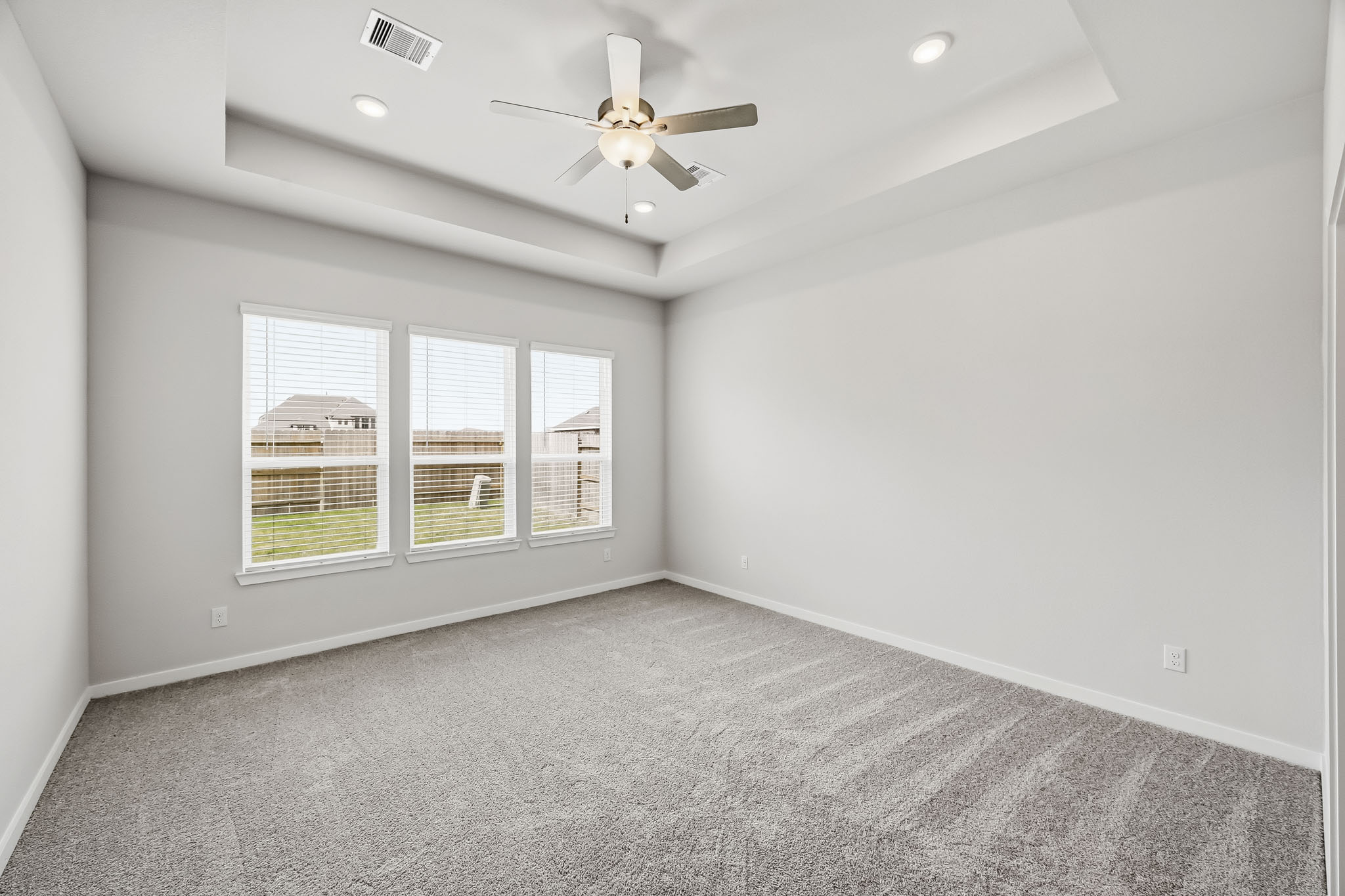 A room with a ceiling fan and a window.