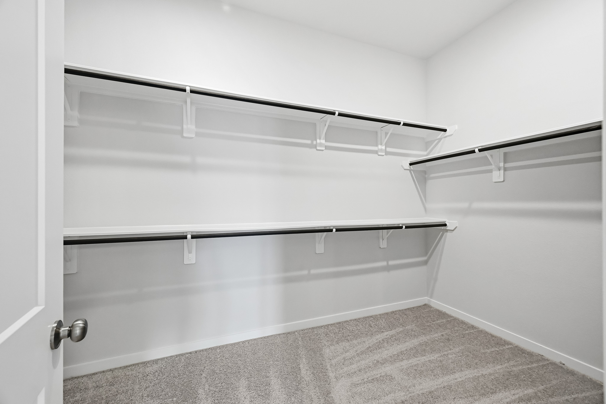 A white wall with a metal bar.