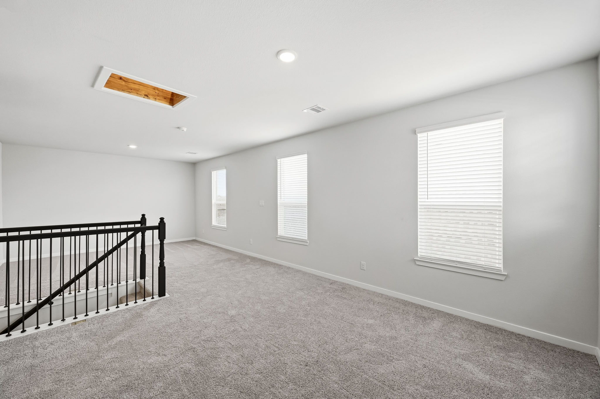 A room with a railing and windows.