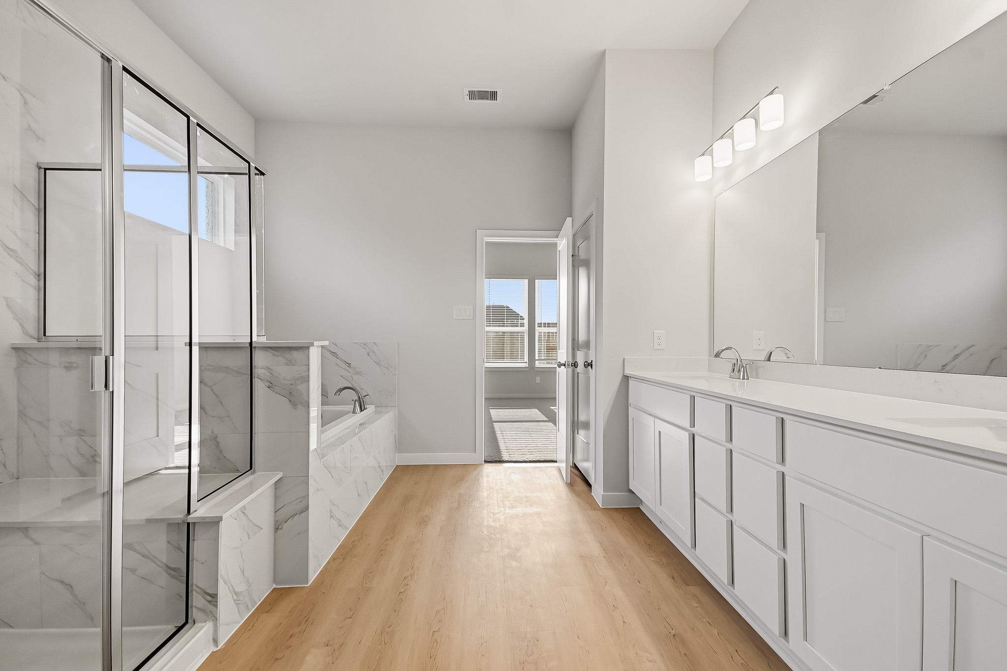 A bathroom with white cabinets.